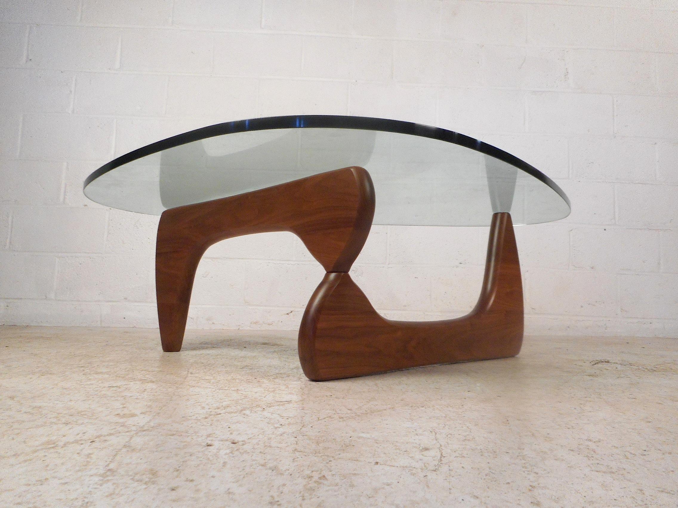 Stunning midcentury coffee/cocktail table by Isamu Noguchi. Both the base and the glass are signed. Expanding finished walnut base with a hefty 3/4 inch thick piece of beveled glass serving as the tabletop. A Classic midcentury design sure to please