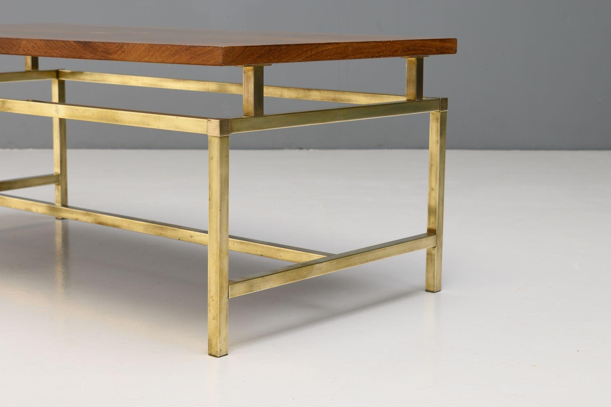 Tavolino da caffè di metà secolo di S.I.M. con piano in teak massiccio e base in ottone lucido. K.K. circa 1960.

H. H. x L. 97 cm. x P. 51 cm.