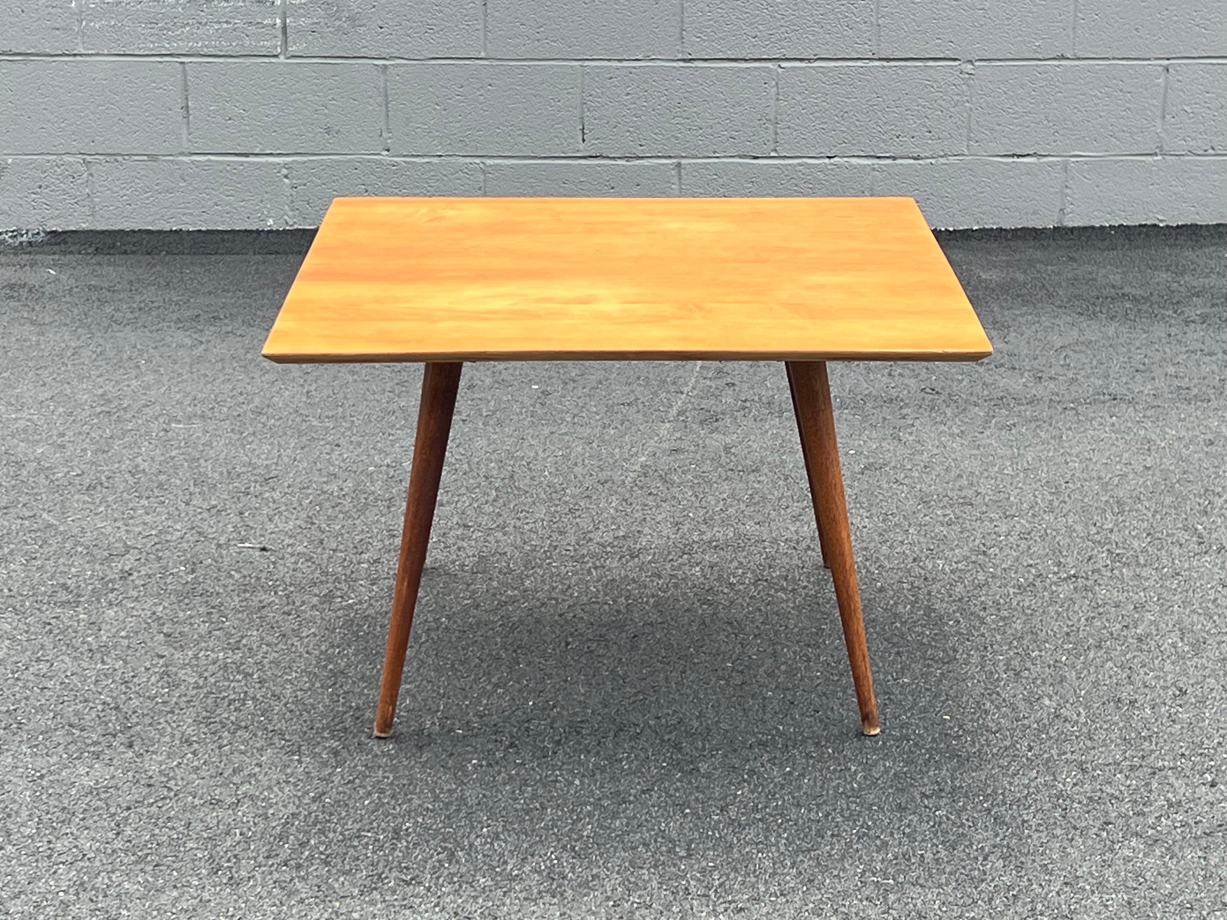Mid-century minimalistic coffee table designed by Paul McCobb for Planner Group, USA. This low-profile coffee table is made from beautifully crafted solid maple wood. Flared long legs compliment the square top well. Minimalist in design, therefore