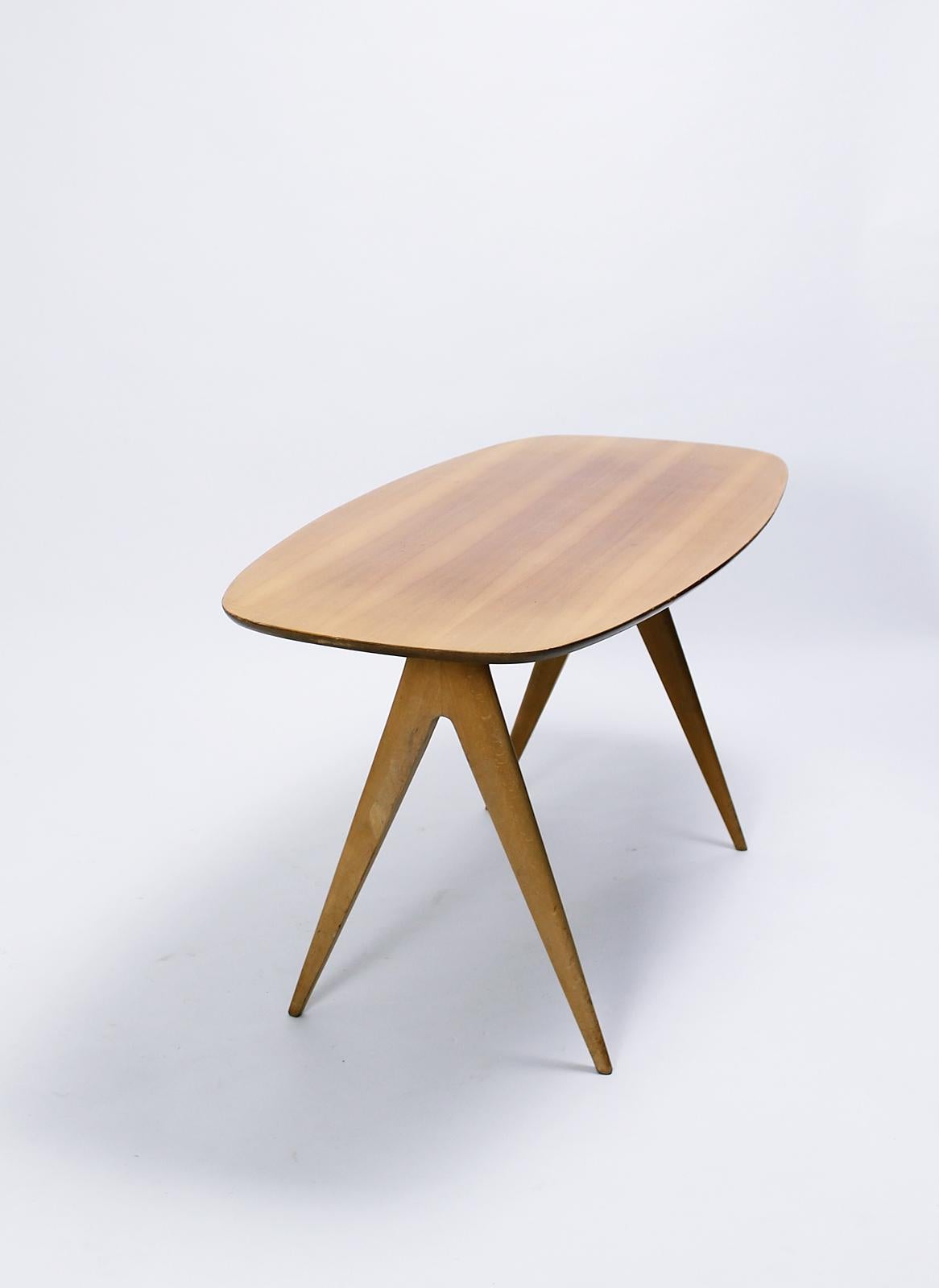 Very nice Italian origin Mid-Century Modern coffee or cocktail table on compass shaped beech legs and walnut veneer top. In good vintage original condition.