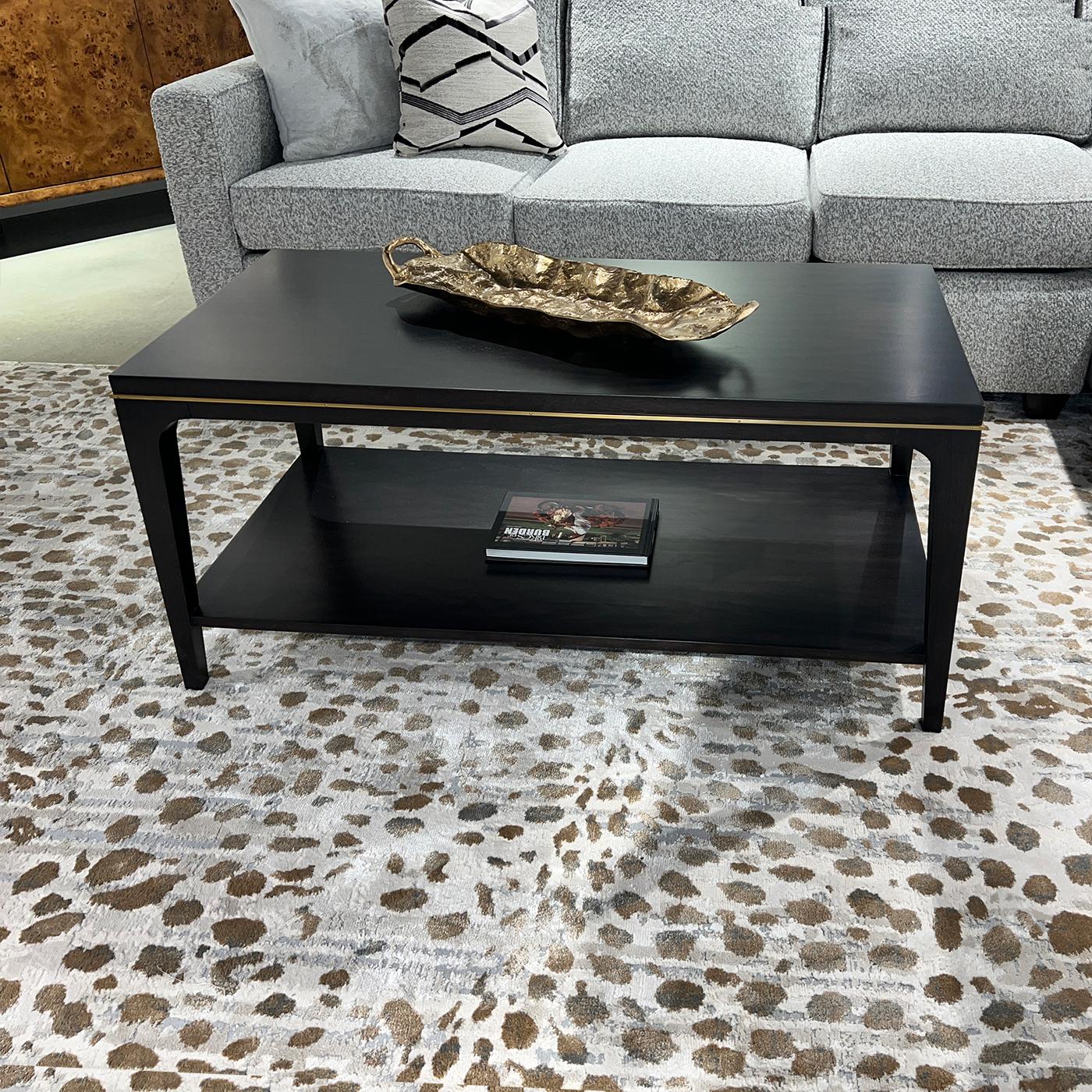 Le plateau est lisse et le tablier est sculpté et orné d'un élégant accent en laiton.

Fabriqué en acacia pour garantir la durabilité et une finition expresso riche et luxueuse. Les pieds effilés et légèrement évasés apportent une touche de