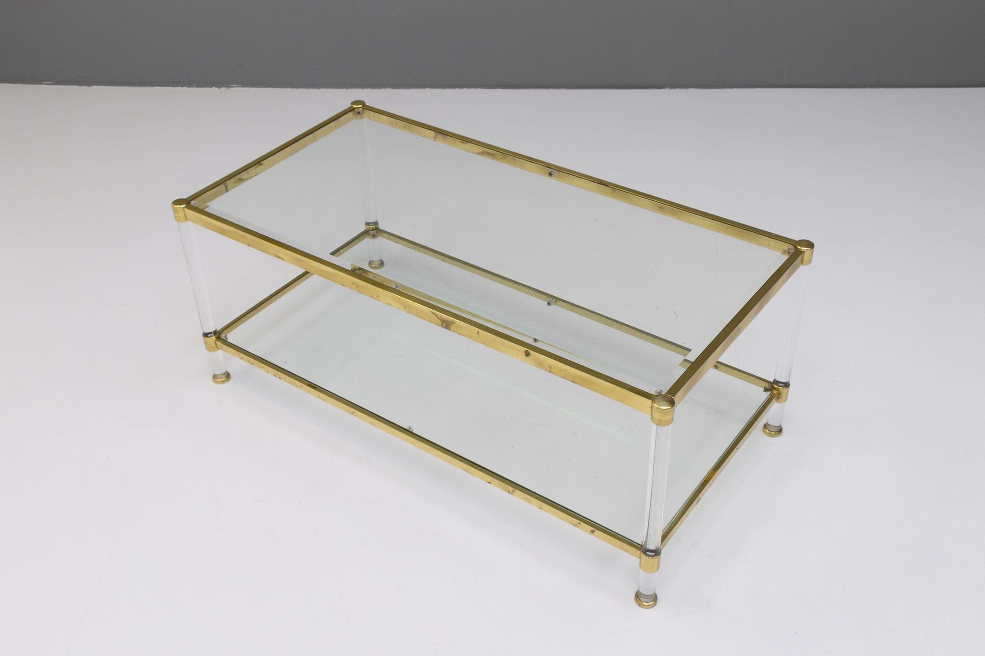 Table basse à deux niveaux avec cadre en laiton, supports en lucite et plateaux en verre biseauté.
Circa 1960.
H 46cm x L 112cm x P 57cm