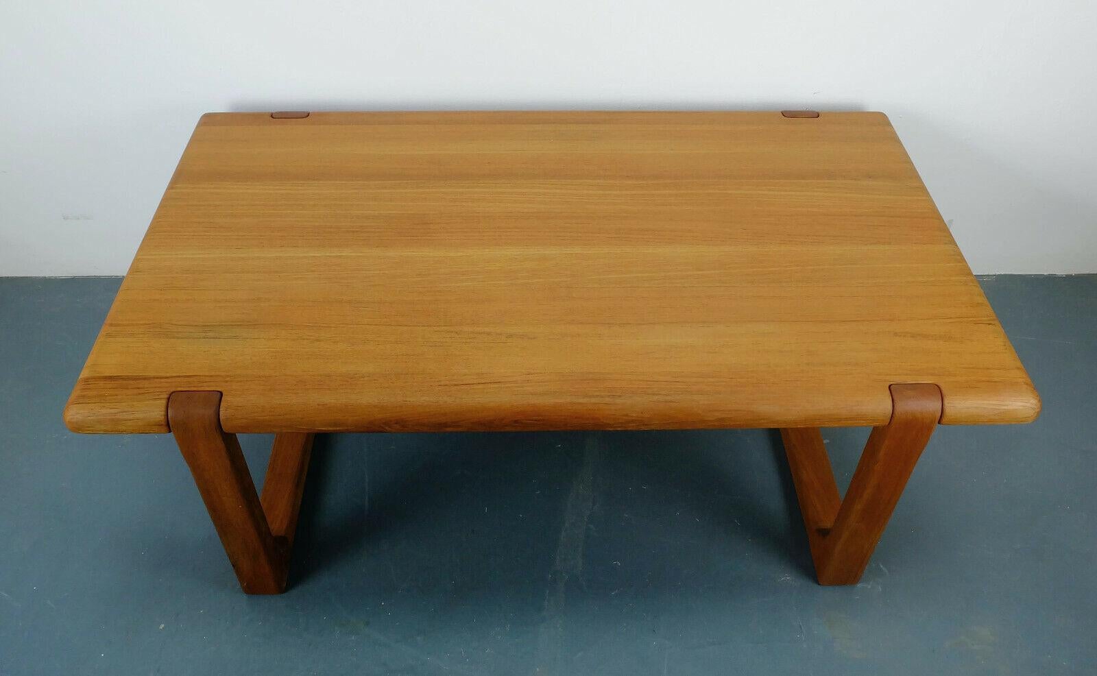 Midcentury coffee table, designed by Niels Bach, made in Denmark. Solid design, yet elegant appearance. Plate and frame solid teak with beautiful grain. Signedz 