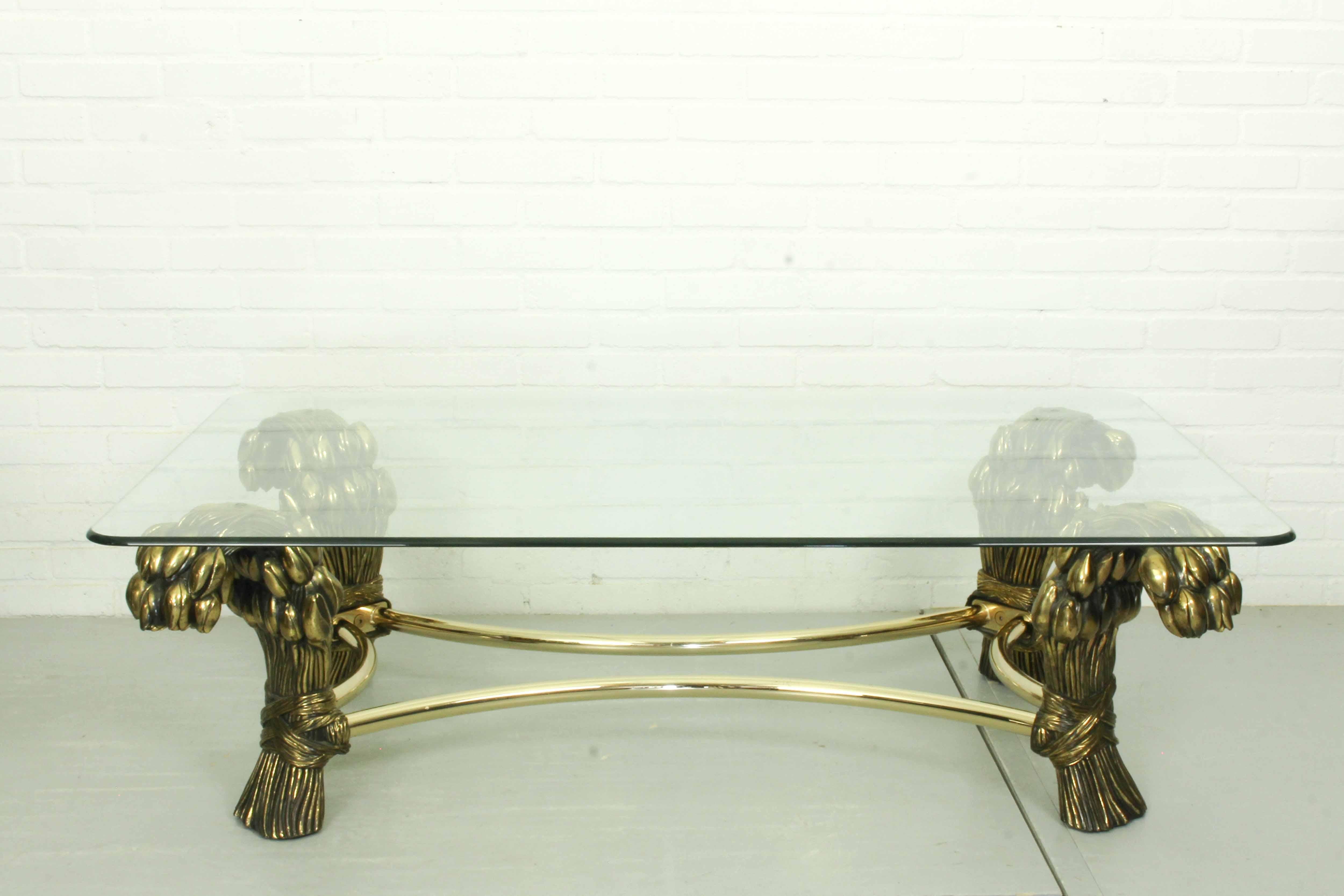 This Unique coffee table was designed by Willy Daro. The table has a thick glass top on heavy brass legs shaped as tulips!
  