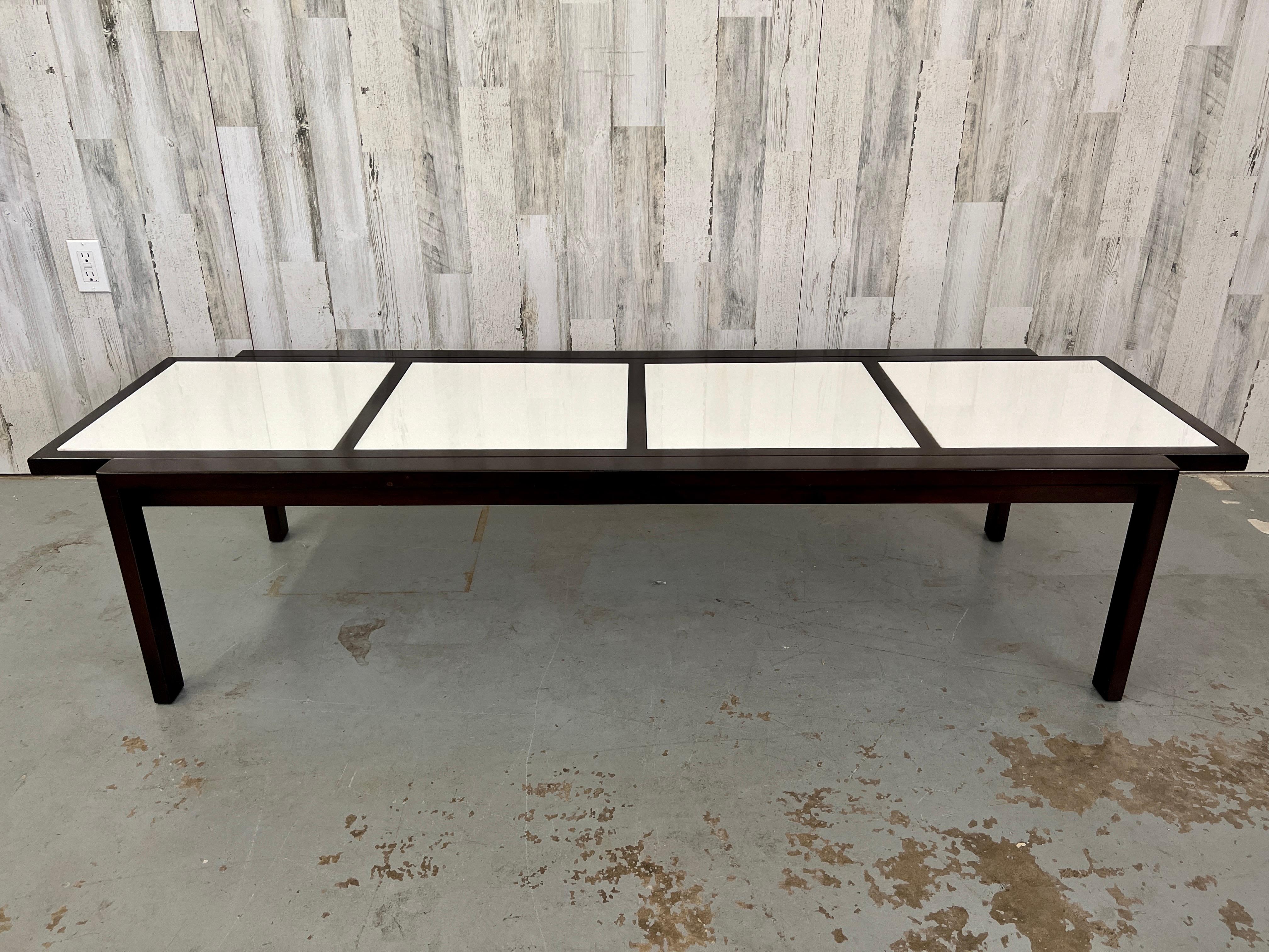 Modernist ebonized cocktail table with milk glass tiles.