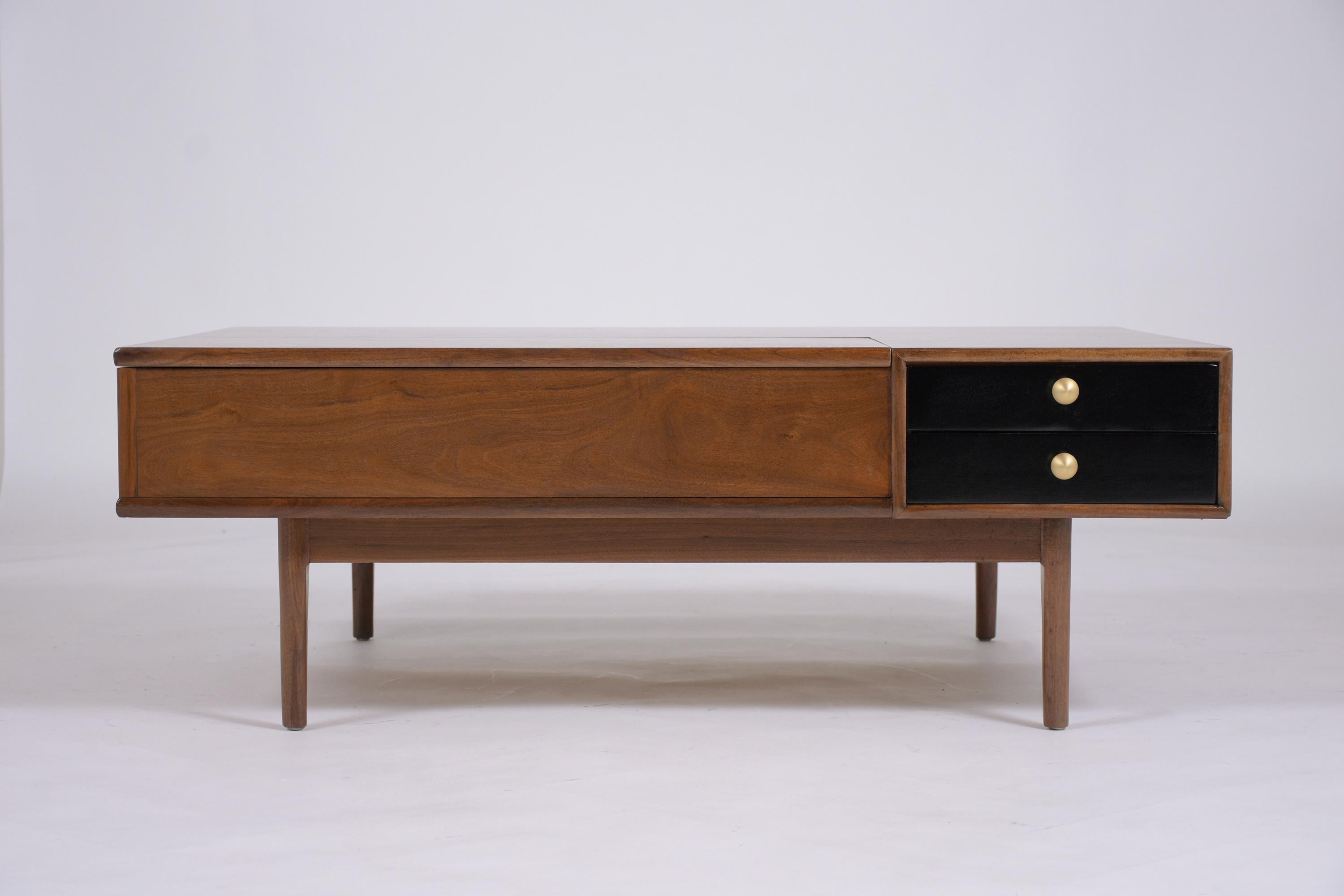 An extraordinary mid-century modern rectangular walnut coffee table beautifully crafted in walnut wood that has been fully restored by our team of professional craftsmen. This unique coffee table features a sleek design stained in dark walnut and