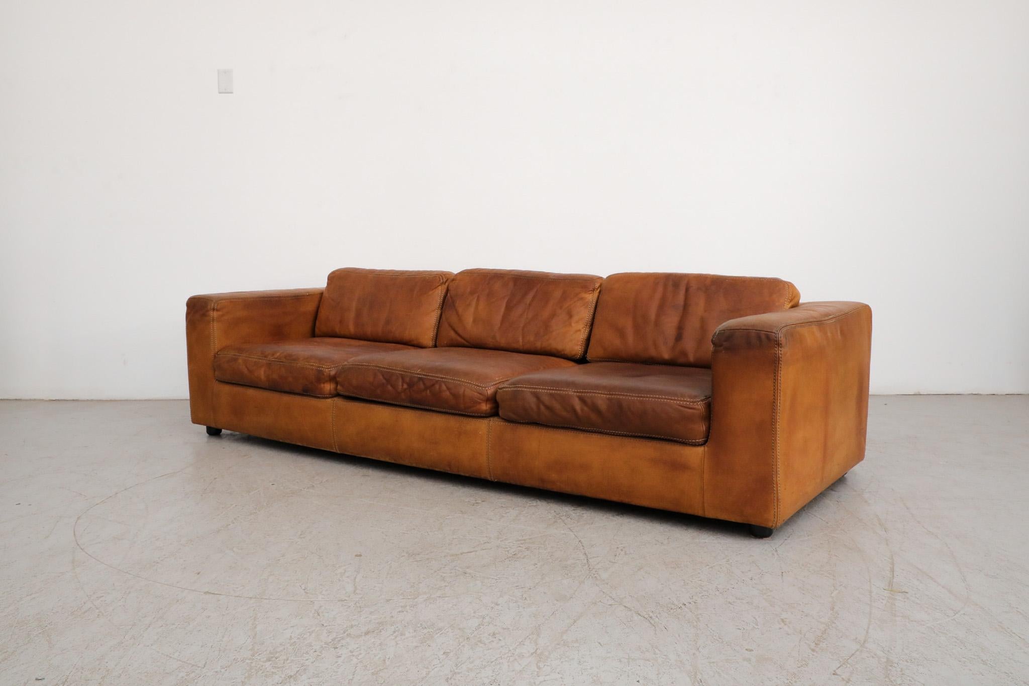 Mid-Century natural leather streamline three seater sofa. Large and comfy natural leather sofa with removable cushions and attractive patina. In original condition with visible wear consistent with age and regular use. 