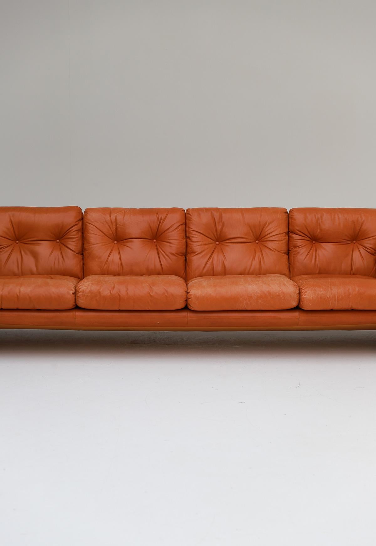 Very comfortable four-seat sofa model Coronado by Tobia Scarpa for B&B Italia. This large edition is not in production any more. It has soft cognac colored leather cushions and frame. The sofa is very comfortable due to the thick cushions. B&B