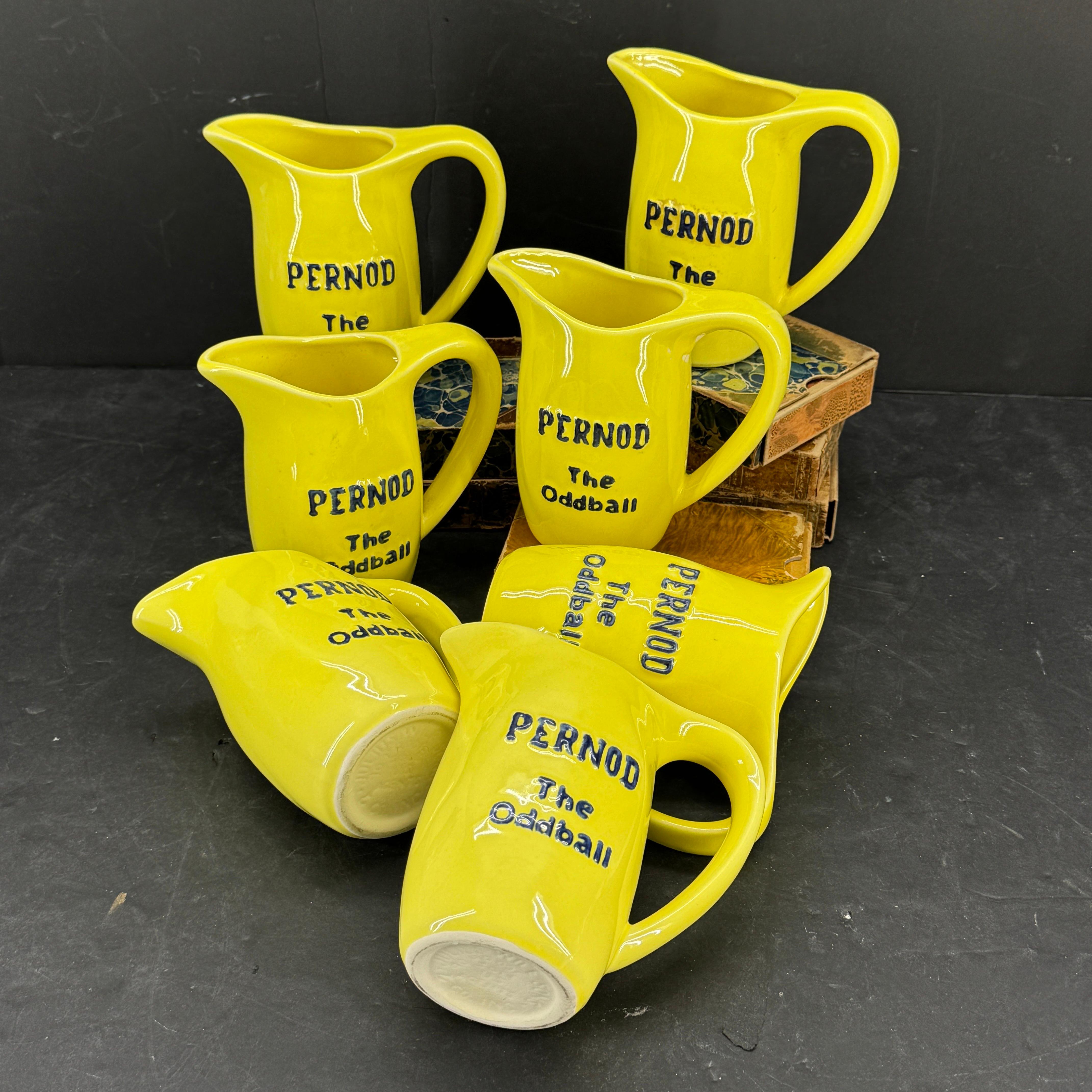 Impressionnante collection de sept pichets Pernod The Oddball en céramique jaune vintage. Cette collection serait parfaite sur une étagère ou utilisée comme ustensiles de bar dans un bar ou un restaurant de style classique ou du milieu du siècle.