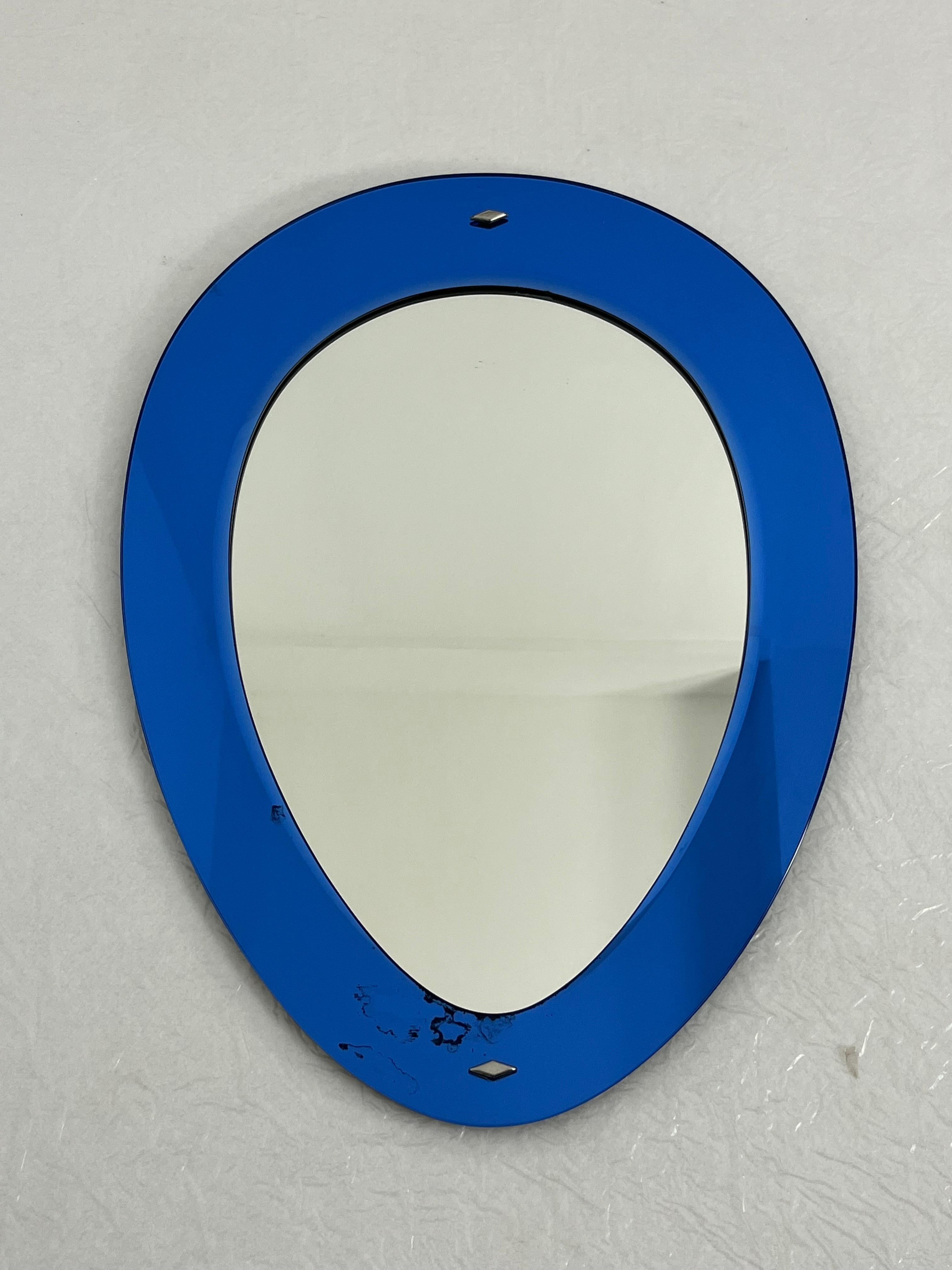 Mid-century colored wall mirror attributed to Cristal Arte, 1960s
Intact and in good condition, with minor signs of aging.
Blue border.
Distinctive inverted teardrop shape.

Insured shipping in a wooden crate with appropriate packaging via DHL