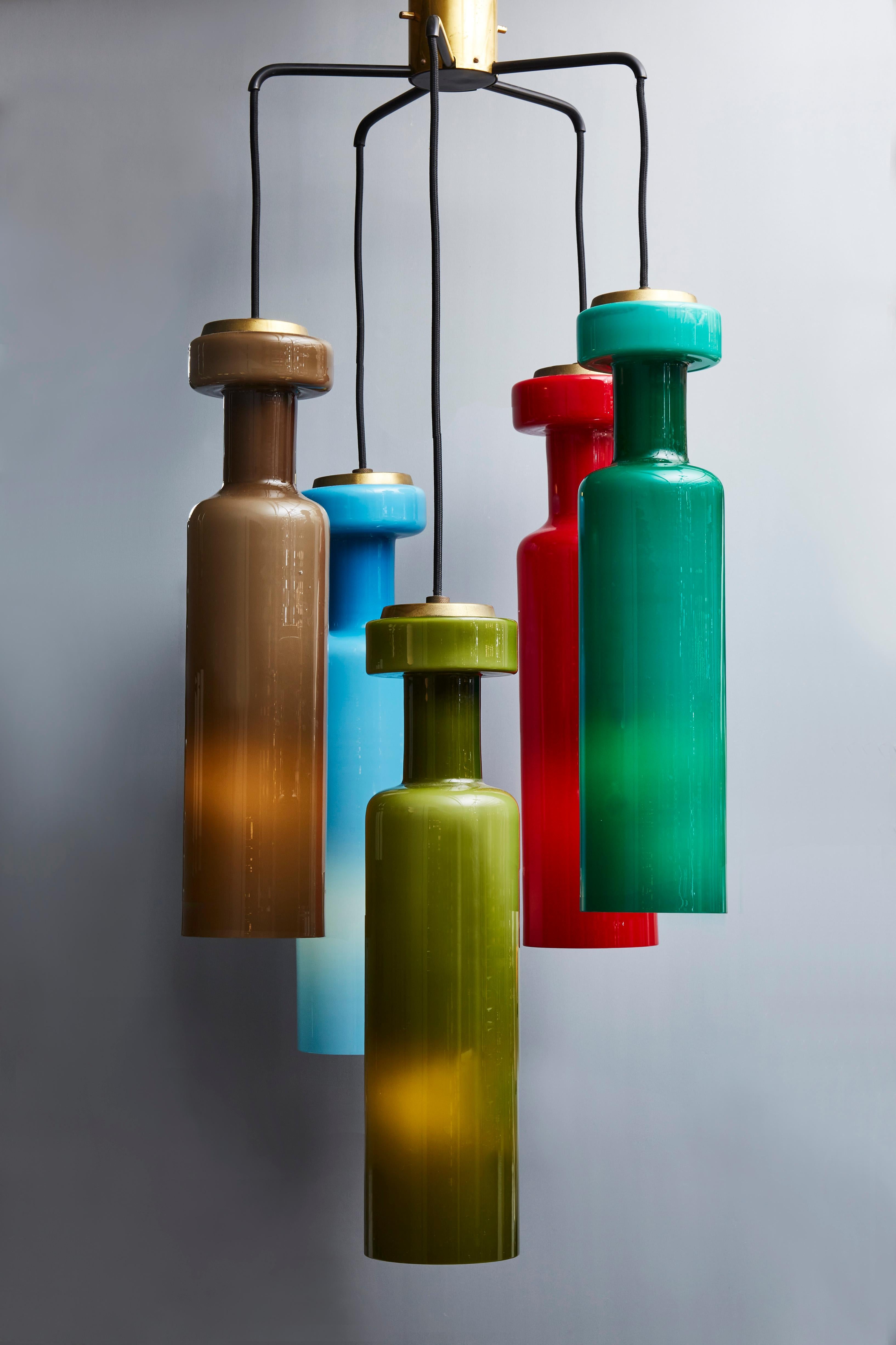 Midcentury chandelier made of five colored glass pendants suspended by their adjustable wire to a star-shaped metal structure.