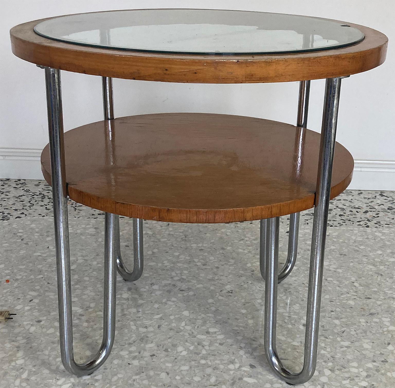 Interesting round table manufactured by Columbus Mobili Razionali in Milano.
Four typical chromed tubular legs support an intermediate wood shelf and glass top inside wooden frame.
  