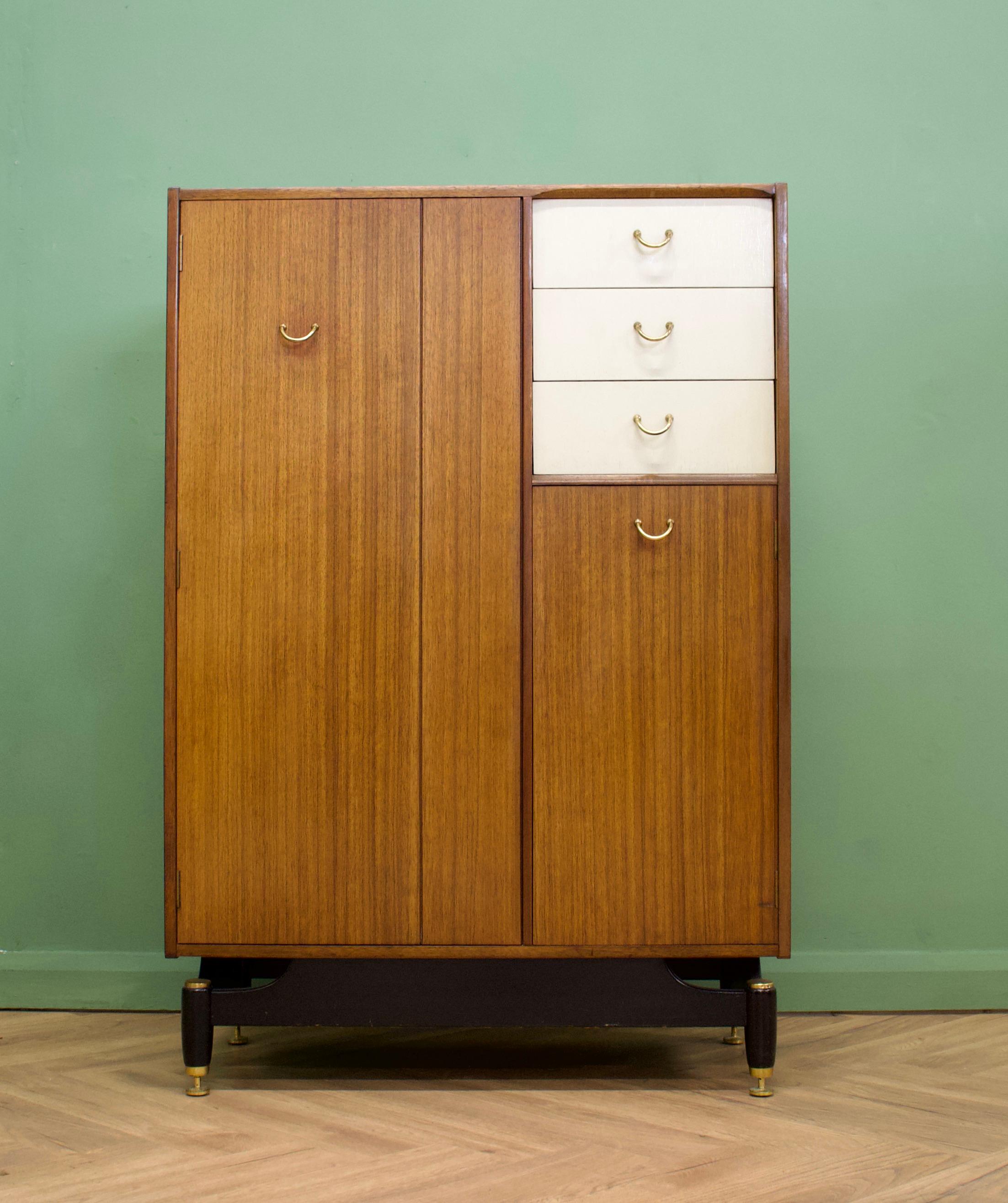 Mid-Century Modern compact wardrobe (Compactum).
Manufactured by G-Plan in the UK. 
Features a pull-out hanging rail inside the left cupboard, 1 shelf in the bottom right cupboard and 3 drawers - one has an internal pullout mirror.