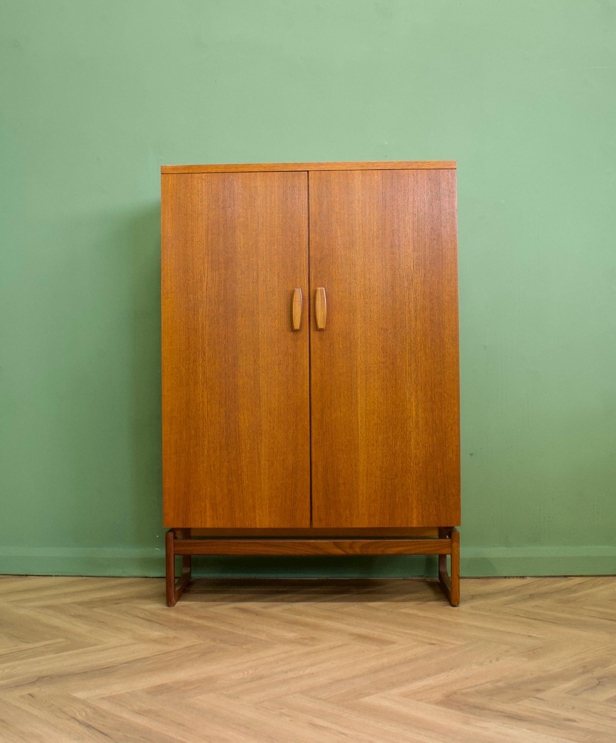 A beautiful quality teak compact wardrobe/compactum from the Quadrille rage by G Plan, circa 1960s
The piece features a hanging rail compartment to one side and two drawers and removable shelves to the right hand side - standing on solid teak sleigh
