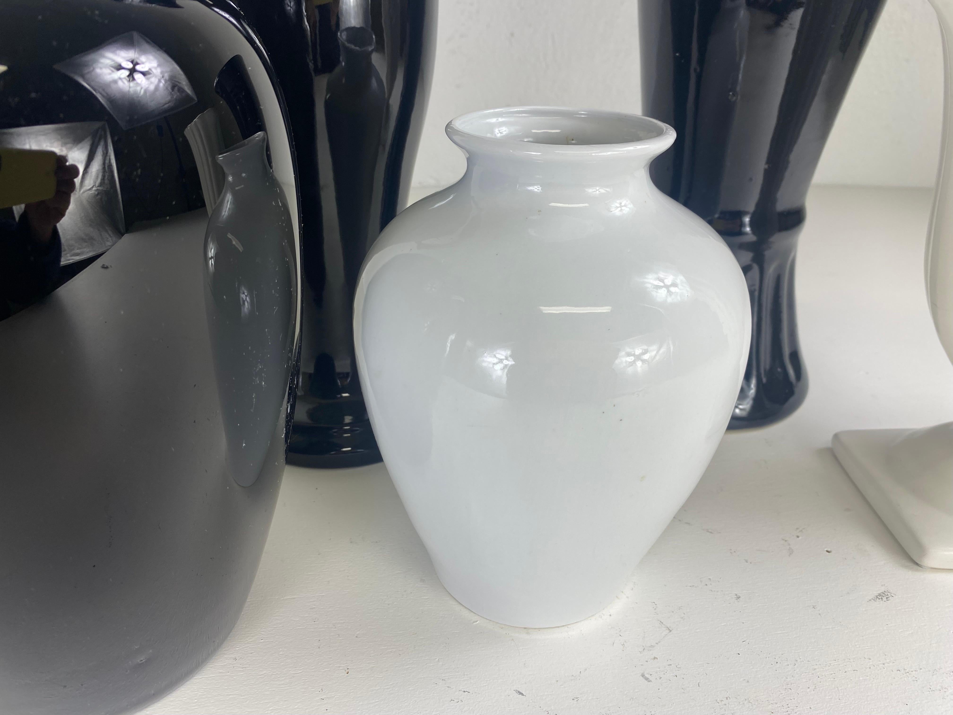 This is a complementary grouping of black and white mid century pottery vases. Please note the vases measurements from left to right the small white vase on the left end is 5 1/2×5 1/2×10. The round black vase in front next to it is 7 1/2×7 1/2×10.