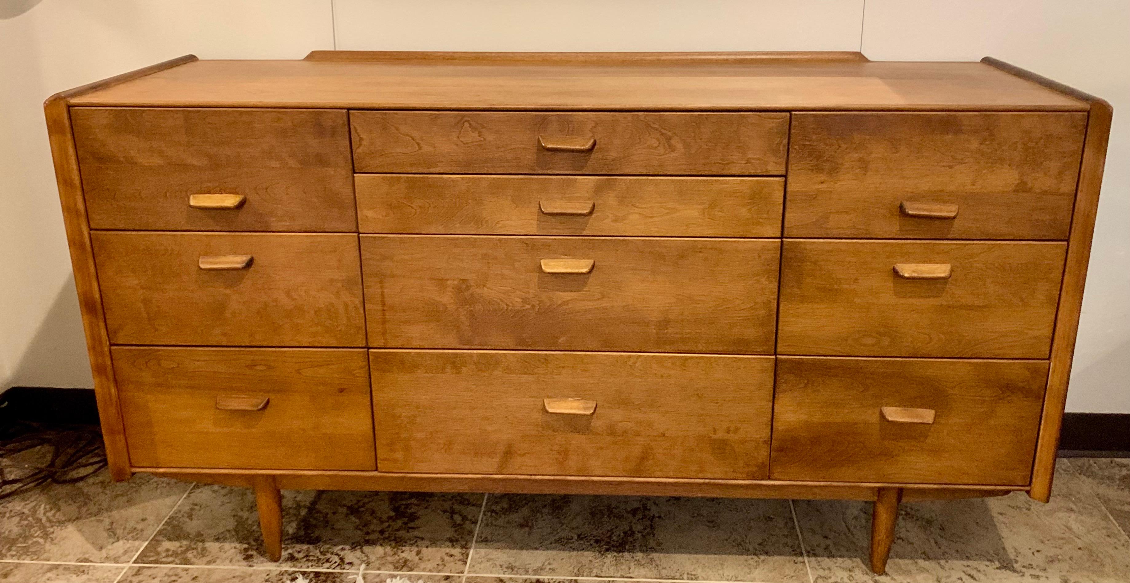 Sleek and clean lines define this mid century Conant Ball triple dresser and matching mirror. It features a beautifully grained birch case with built in drawer pulls. There are ten drawers that offer plenty of storage. Beautiful condition!
Mirror