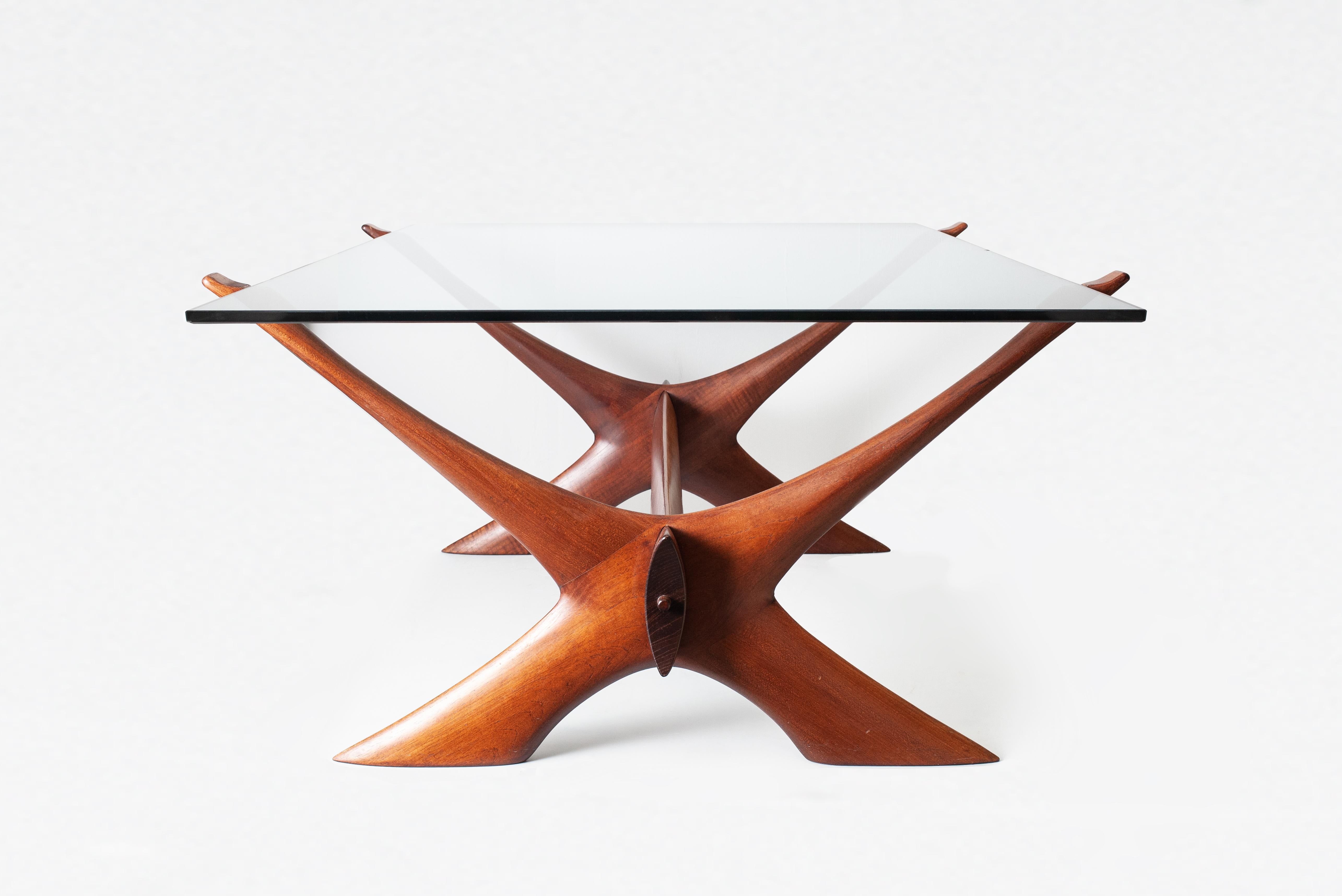A great example of the “Condor” coffee table designed by Fredrik Schriever-Abeln for Örebro Glas, Sweden. The subtly green tinted glass top allowing the exquisitely crafted teak base in its double x configuration joined together by a cross beam to