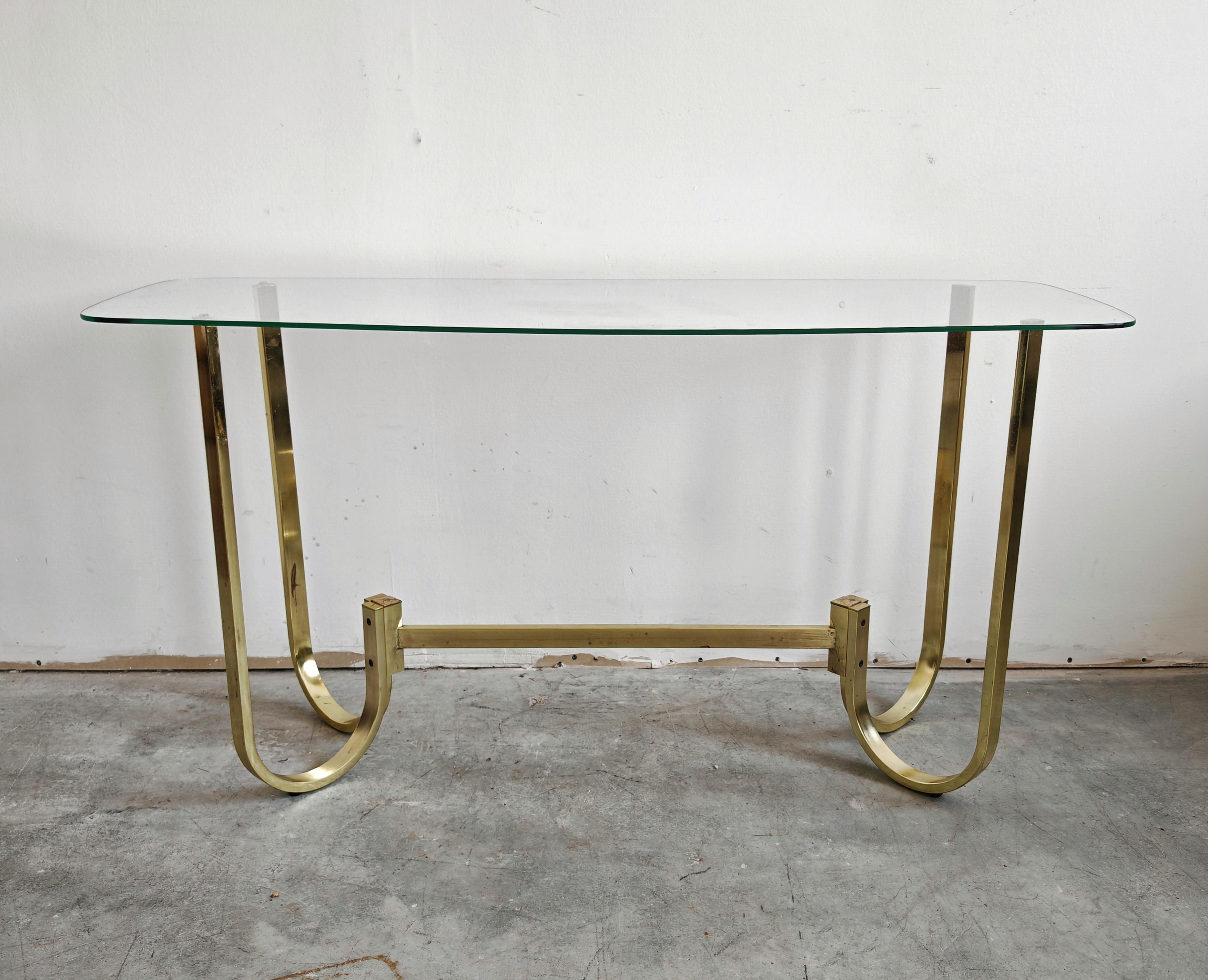 In this listing you will find a beautiful, sleek Mid Century Modern console table. It is done in gold painted aluminum, with a glass top. Made in West Germany in the 1970s.

The console is in a very good vintage condition with some small signs of