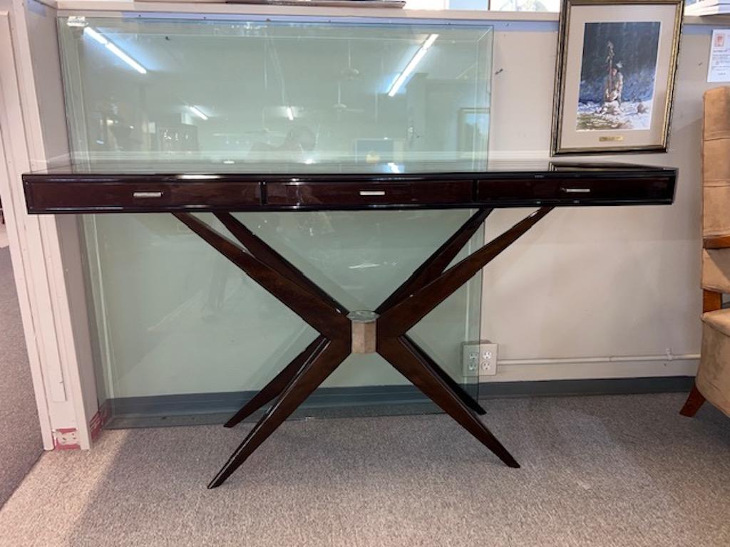 Console is made out of high quality walnut wood. Has 3 slim drawers with chrome handles. Four elongated legs are connected in the middle with decorative metal element, creating X shape.

Condition is perfect, restored
Continental, c.