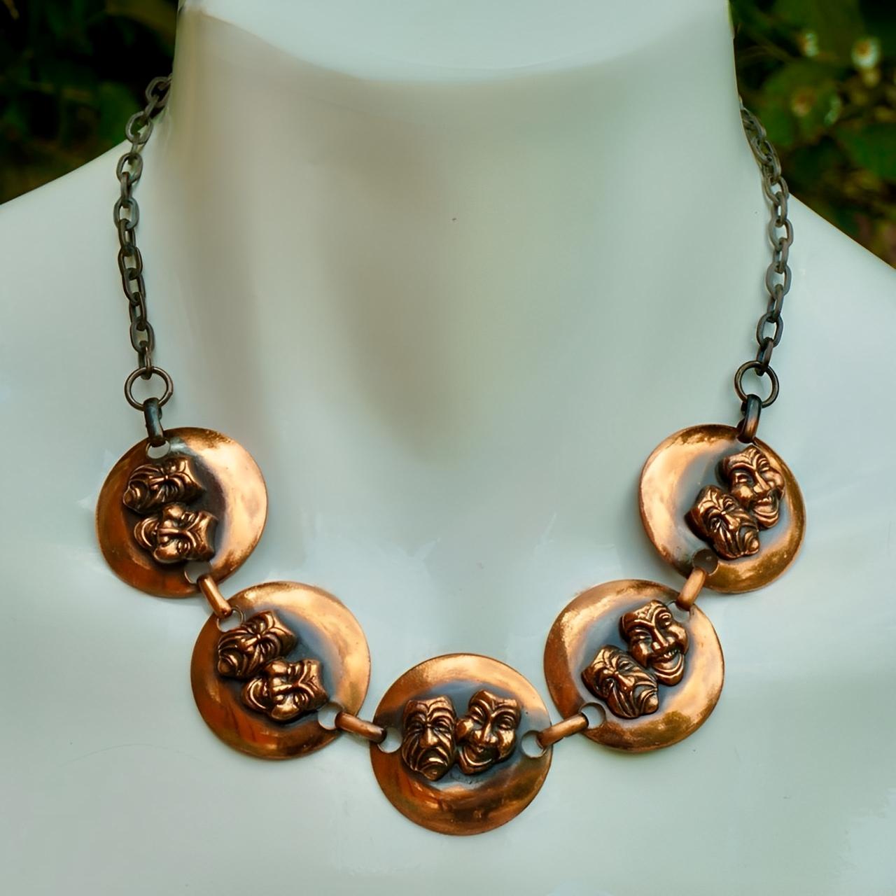Copper mid century anodized link chain necklace and earring set, featuring a wonderful comedy and tragedy design, set in relief.

The necklace has five polished copper links attached to chain, with an adjustable hook clasp. Measuring length