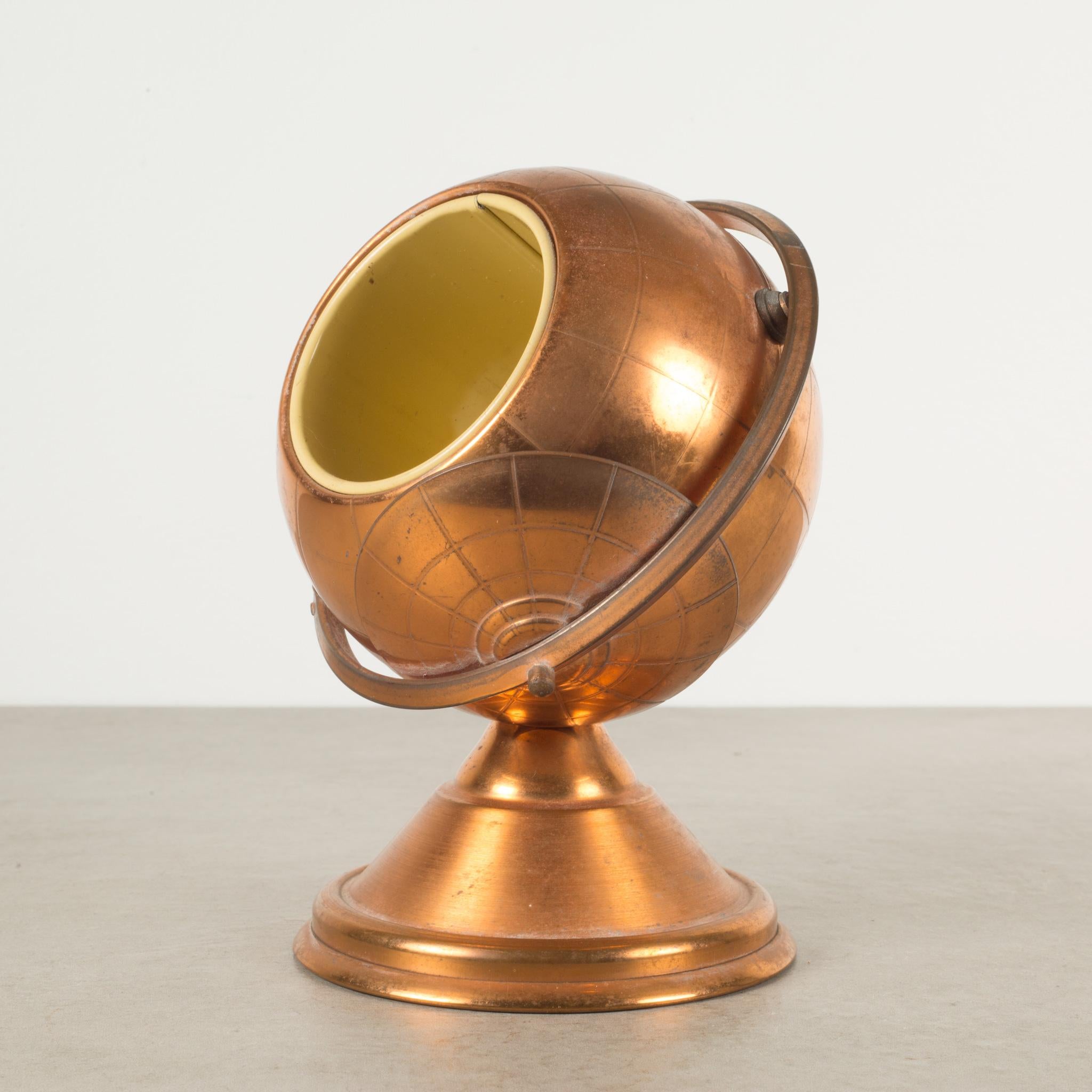 About

This is an original Mid-Century Modern copper cigarette holder. The lid slides open on the globe's axis to reveal a metal interior designed to hold cigarettes.

This piece has retained its original finish and has the appropriate finish for