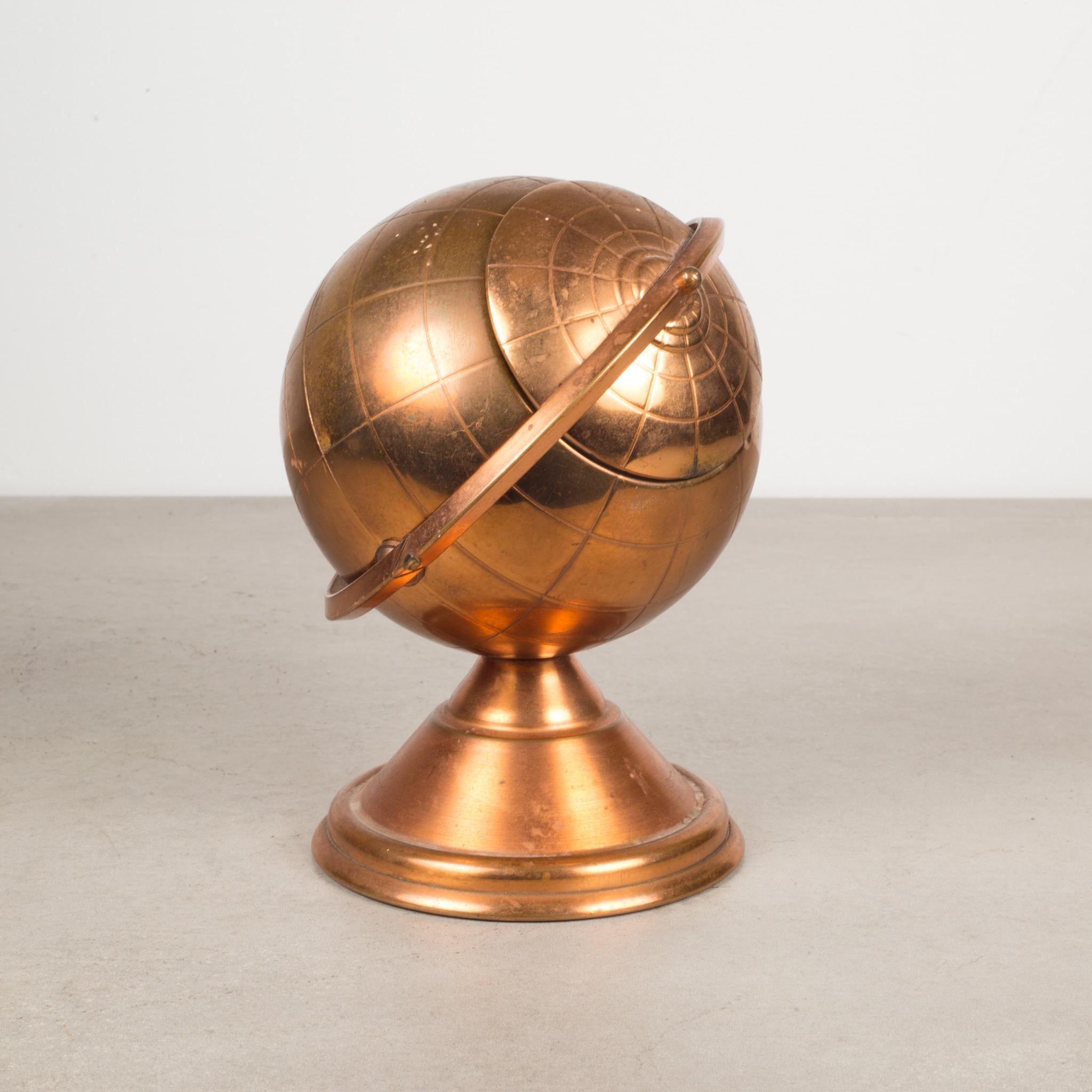 About

This is an original Mid-Century Modern copper cigarette holder. The lid slides open on the globe's axis to reveal a metal interior designed to hold cigarettes.

This piece has retained its original finish and has the appropriate finish