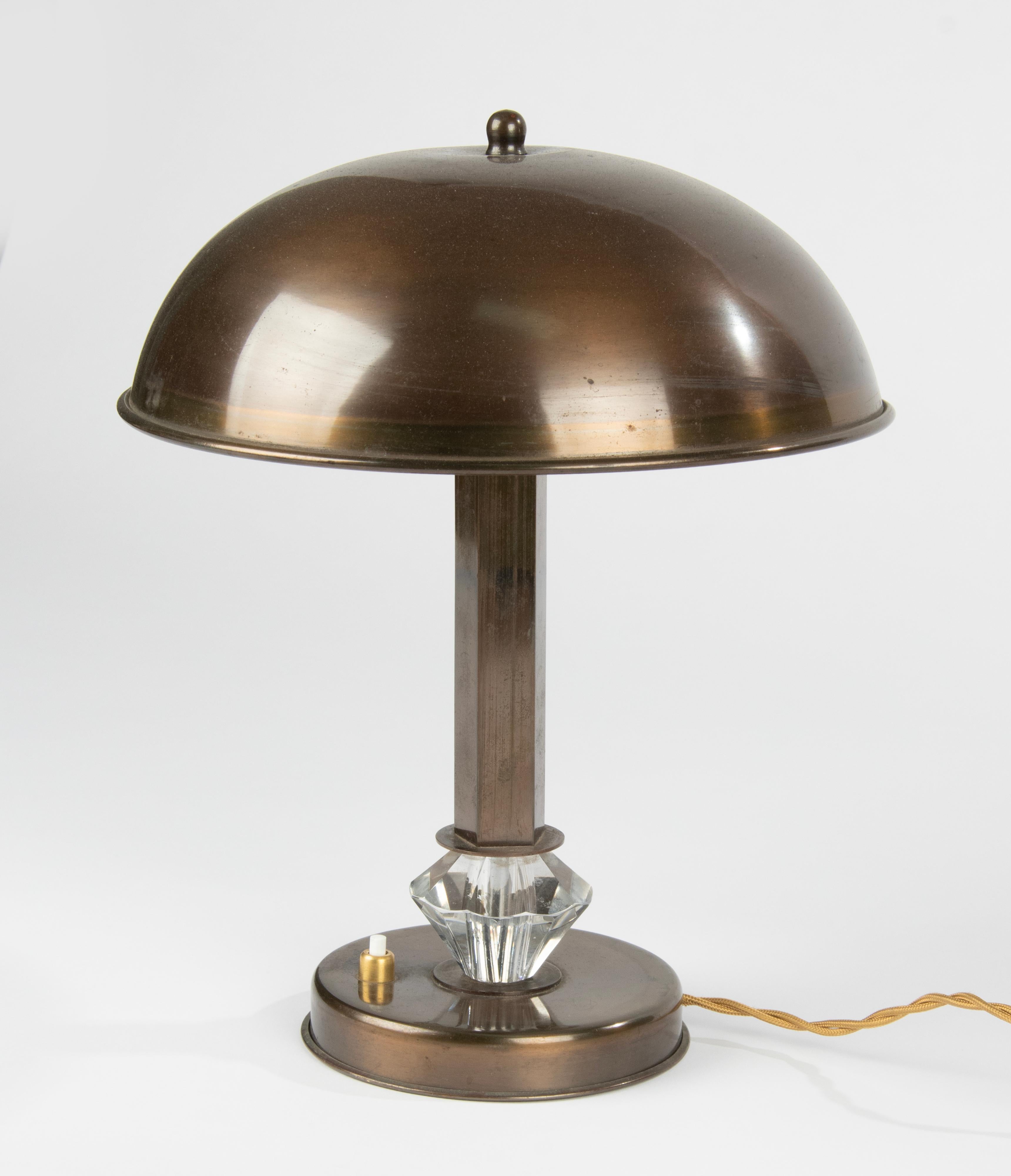 An elegant Art Deco style table or desk lamp, made of copper colored metal. At the bottom of the stem a crystal cut knop. The lamp has a two E27 lamp fittings. The lamp is in working order, the switch also functions. 
Dimensions: 32 () x 26 x 26