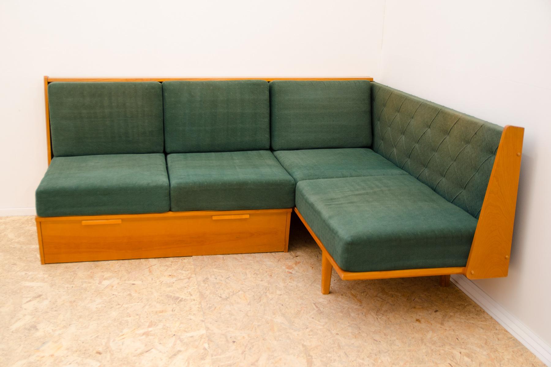 Mid century corner sofa with storage space, made in the former Czechoslovakia in the 1960´s.

This sofa has a veneered beechwood frame and bedding storage. The sofa is in good Vintage condition, showing signs of age and use(faded fabric in a few