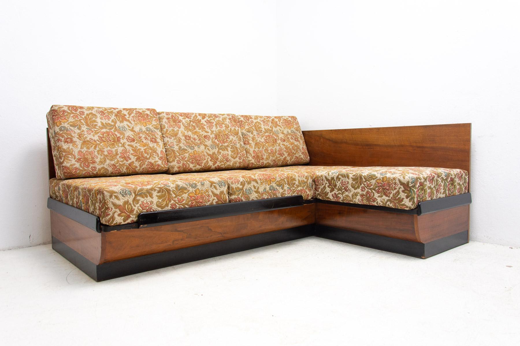 Mid century corner sofa bed designed by Jindrich Halabala. It was made in the former Czechoslovakia in the 1950´s. This sofa features a wooden structure that is veneered in walnut. Sofa is adjustable for sleeping and is in very good condition.

