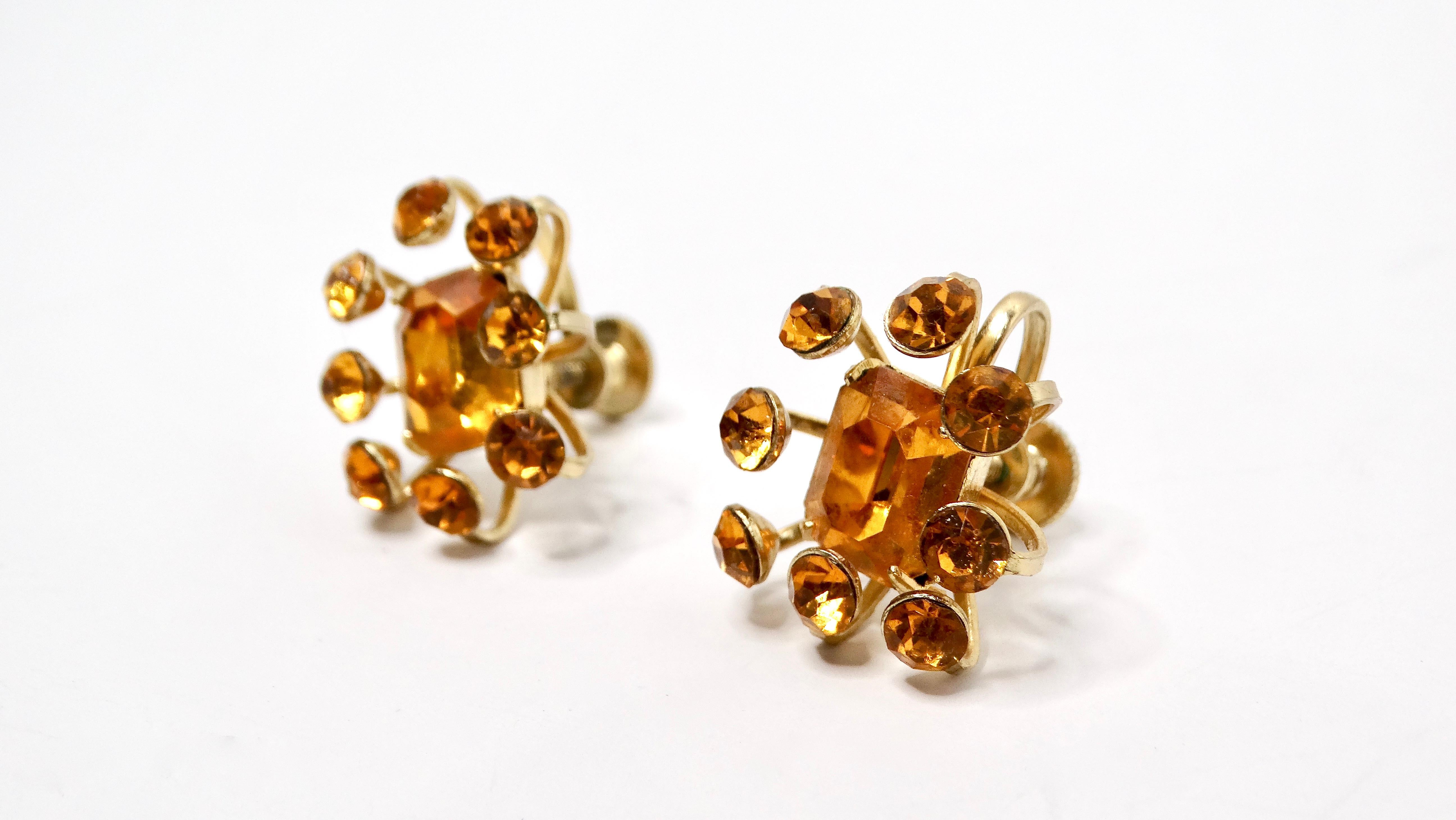 Diese exquisiten Mid Century Coro Topaz Strass Ohrringe 14k vergoldet Schraube zurück Ohrringe sind eine atemberaubende Darstellung der Vintage-Eleganz. Jeder Ohrring hat die Form einer zarten Blume mit einem leuchtenden, topasfarbenen Strassstein