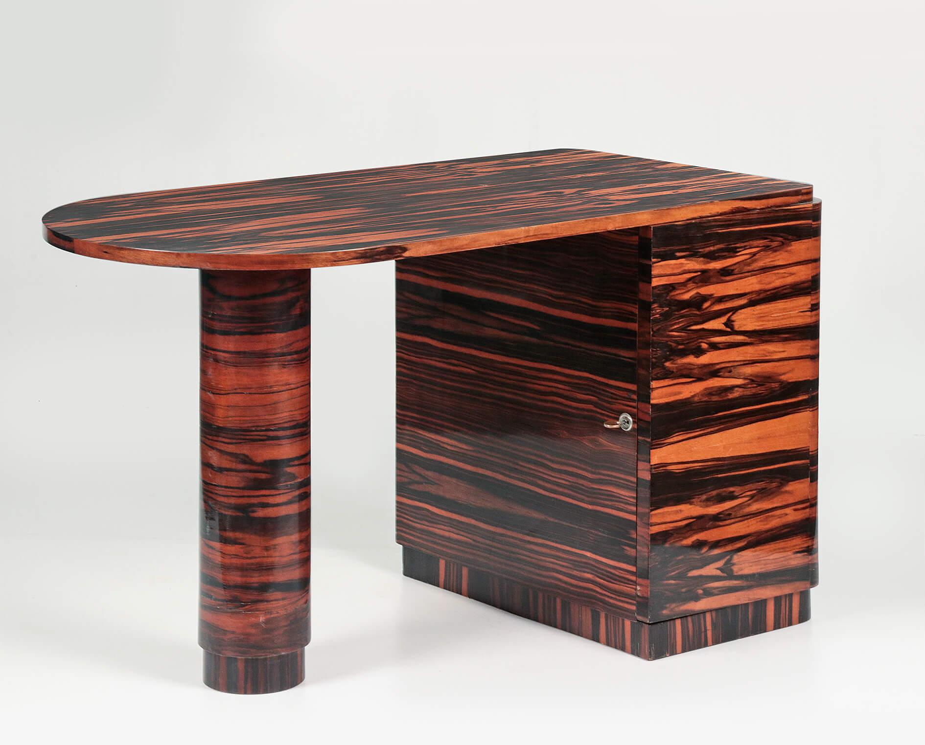 A stylish designed midcentury desk. The whole is veneered with Coromandel / Macassar ebony wood. This hard tropical wood type has a beautiful grain and deep hazel-brown color. There are four drawers on the right side behind the door. This piece of