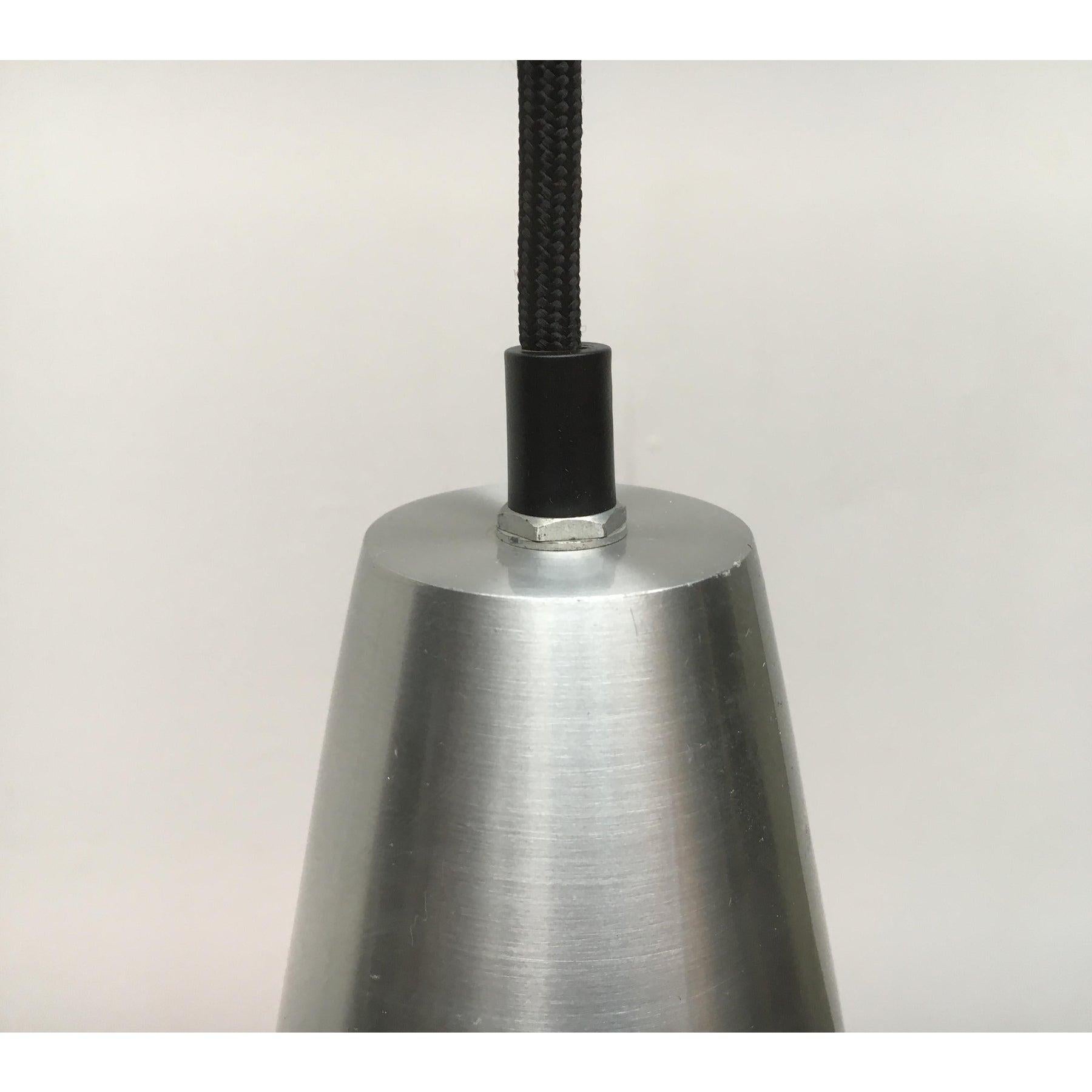 Lampada a sospensione del produttore danese Fog & Mørup su disegno di Jo Hammerborg degli anni '60.

Un design semplice e simmetrico. Colpisce il contrasto tra l'alluminio e il nero opaco. Il corpo della lampada, di colore alluminio, ha una forma