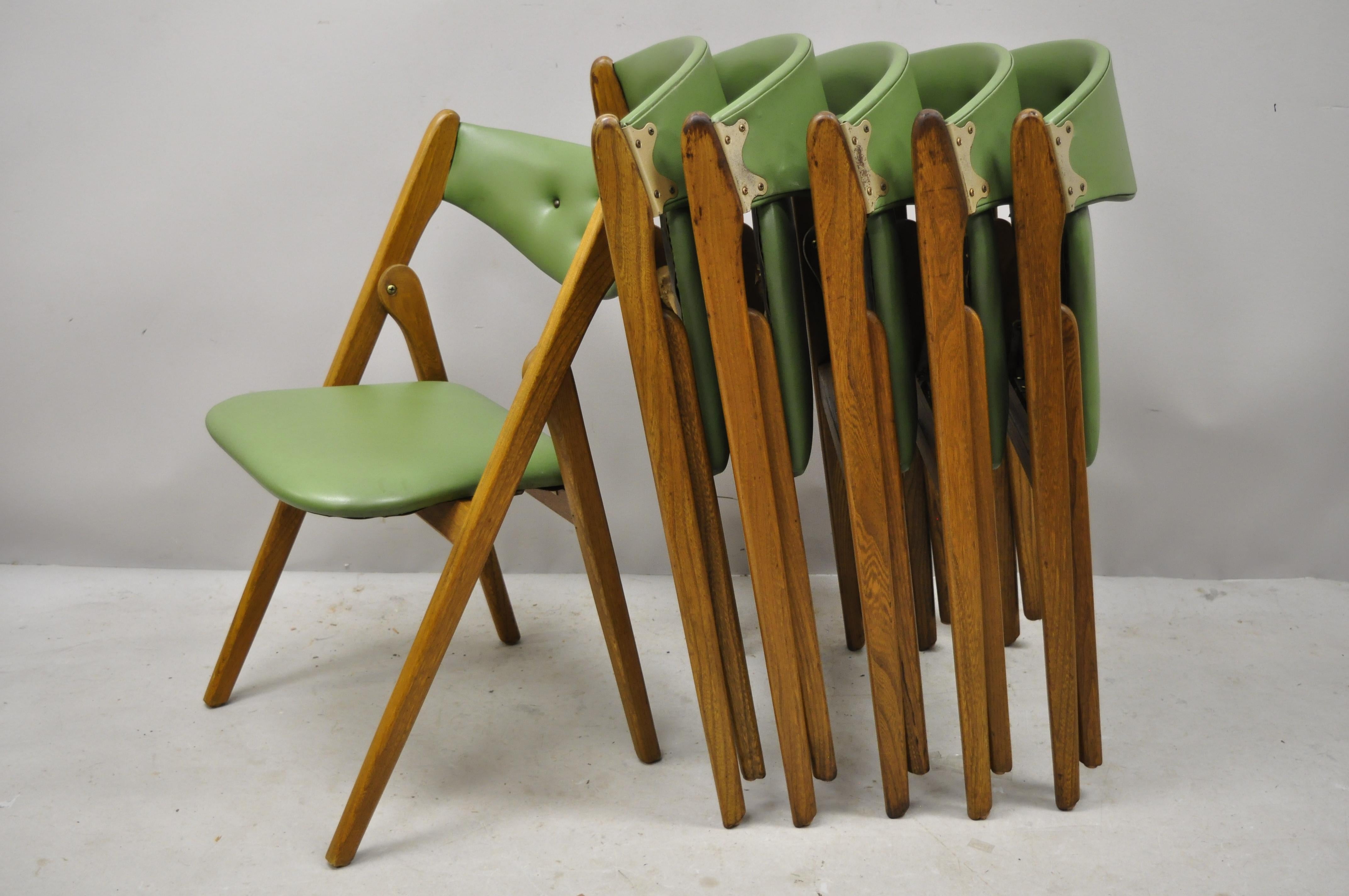 Mid-Century Modern Coronet Wonderfold Norquist green vinyl folding chairs - Set of 6. Item features green vinyl upholstery, (6) folding chairs, solid wood frame, beautiful wood grain, original label, clean modernist lines, quality American