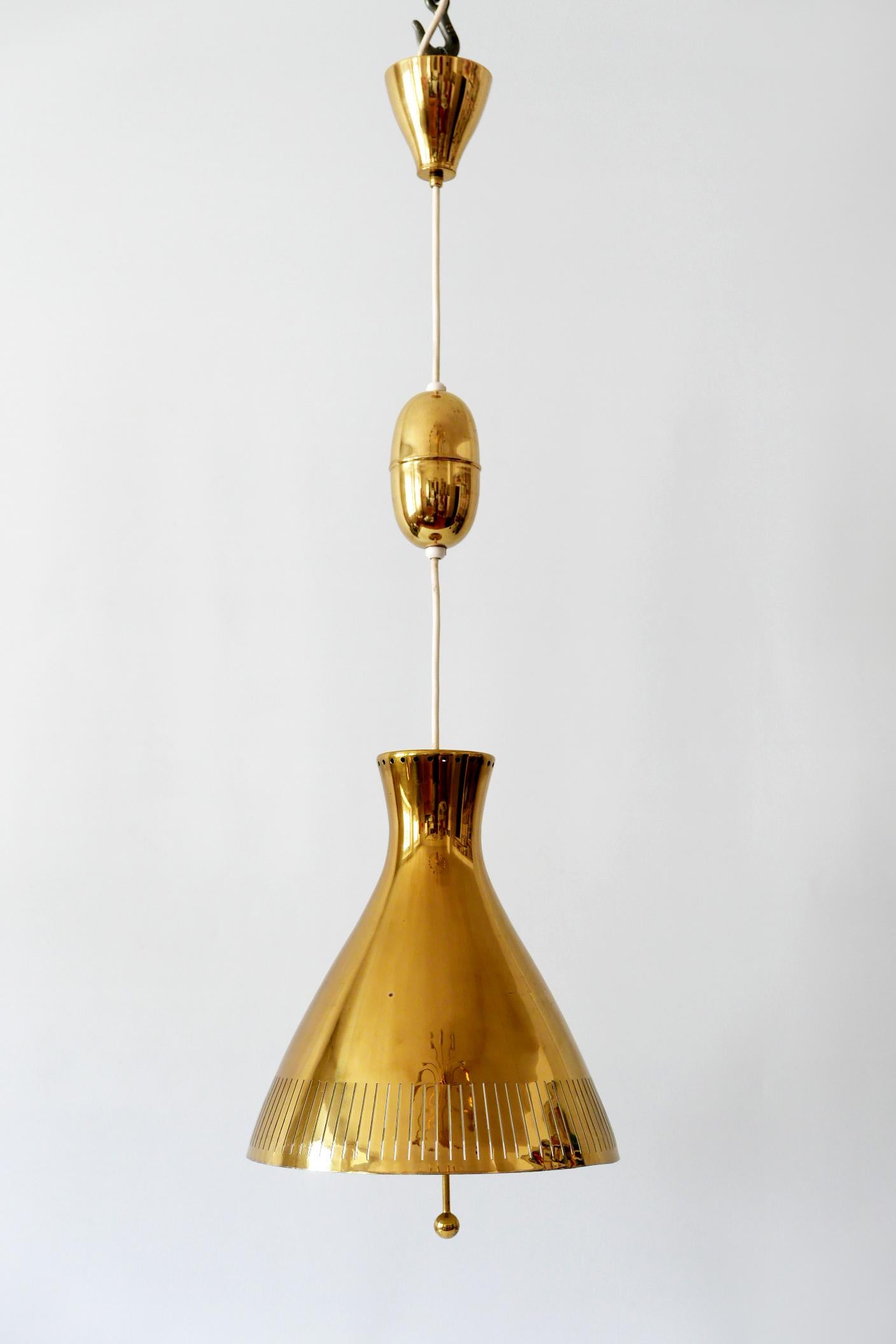 Extremely rare and elegant Mid-Century Modern counterweight / pulley brass pendant lamp or hanging light. Designed and manufactured by Vereinigte Werkstätten, 1960s, Germany.

Executed in perforated brass sheet, it comes with 1 x E27 Edison screw