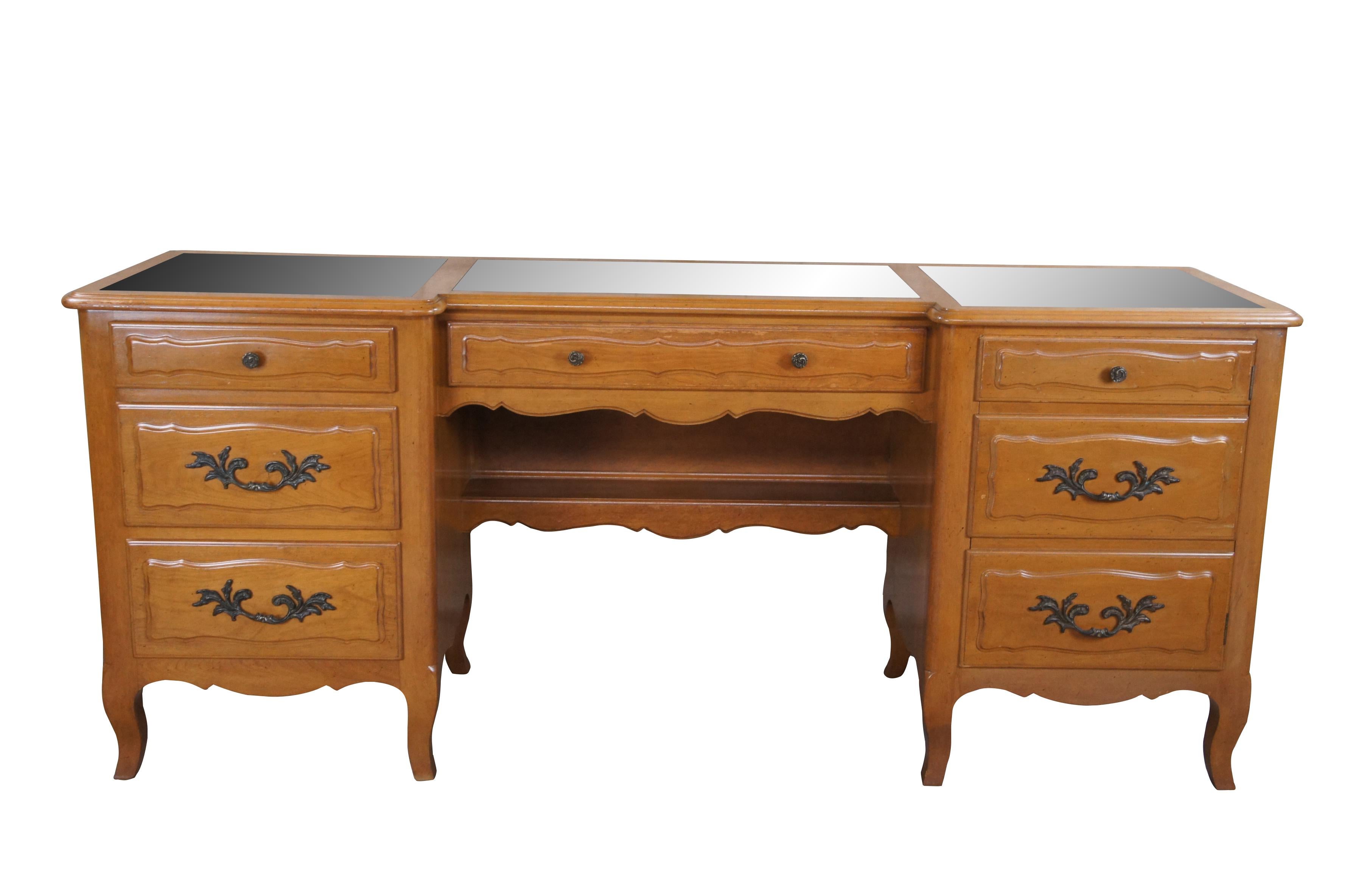 Mid century French Provincial vanity desk or credenza featuring serpentine form with antiqued mirrored top,  four drawers and one cabinet.


DIMENSIONS

20.5
