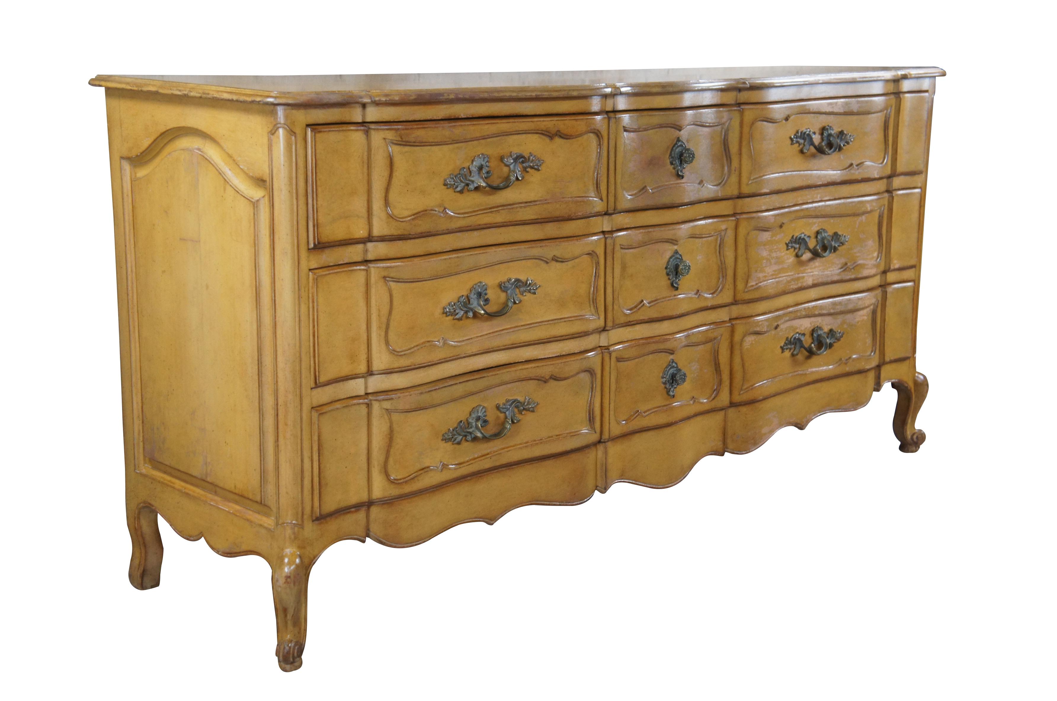 A stout mid century French Provincial dresser featuring serpentine form with nine dovetailed oak drawers, paneled accents and cabriole legs. Attributed to Bethlehem Furniture Co.

Dimensions:
21