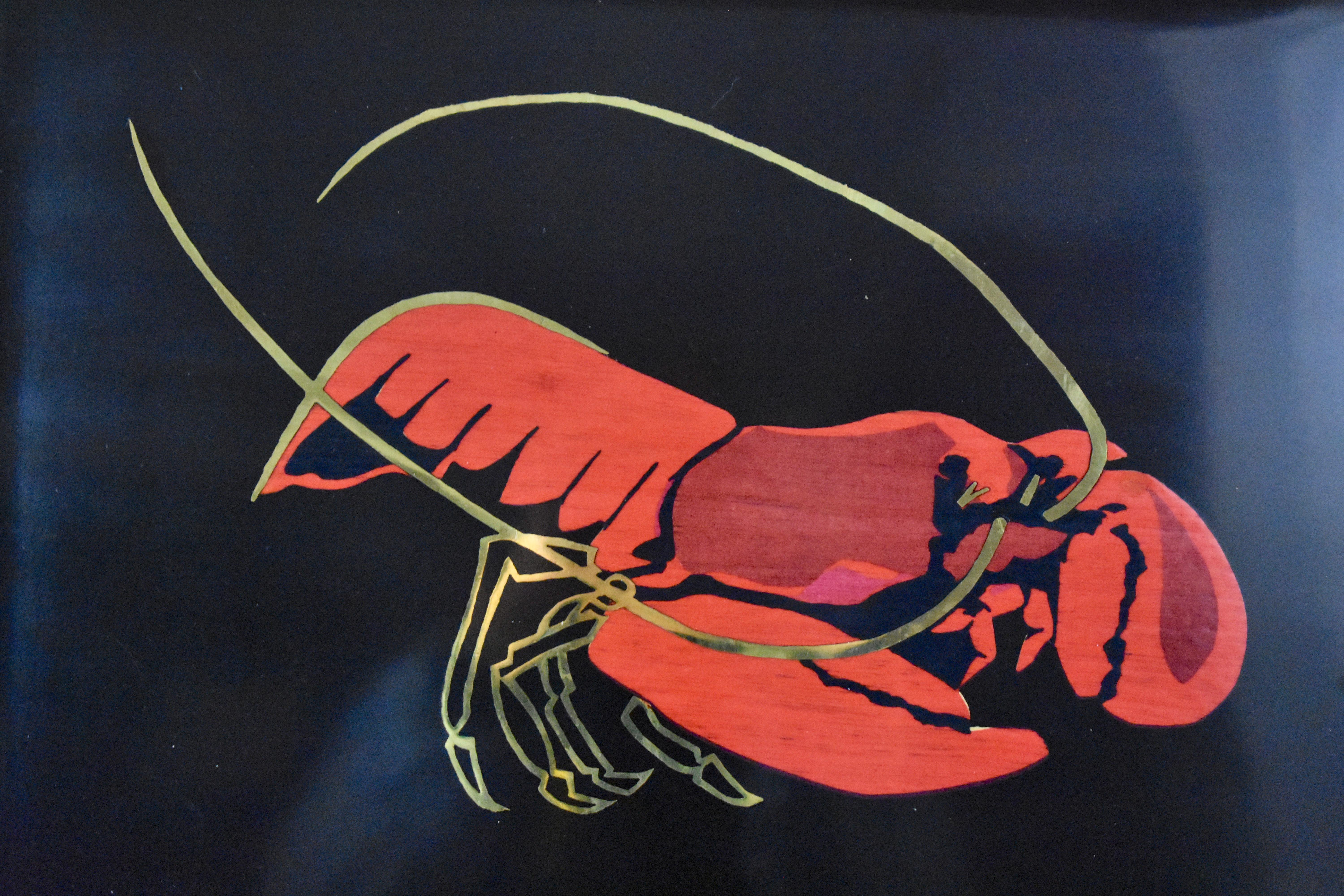 A Mid-Century Modern Era serving tray by Couroc of Monterey, California, (1948-1998) – The Lobster pattern, circa 1960s.

Made of a black resin called ‘Phenolic’ and hand inlaid with the image of a lobster in red dyed wood and brass accents. With