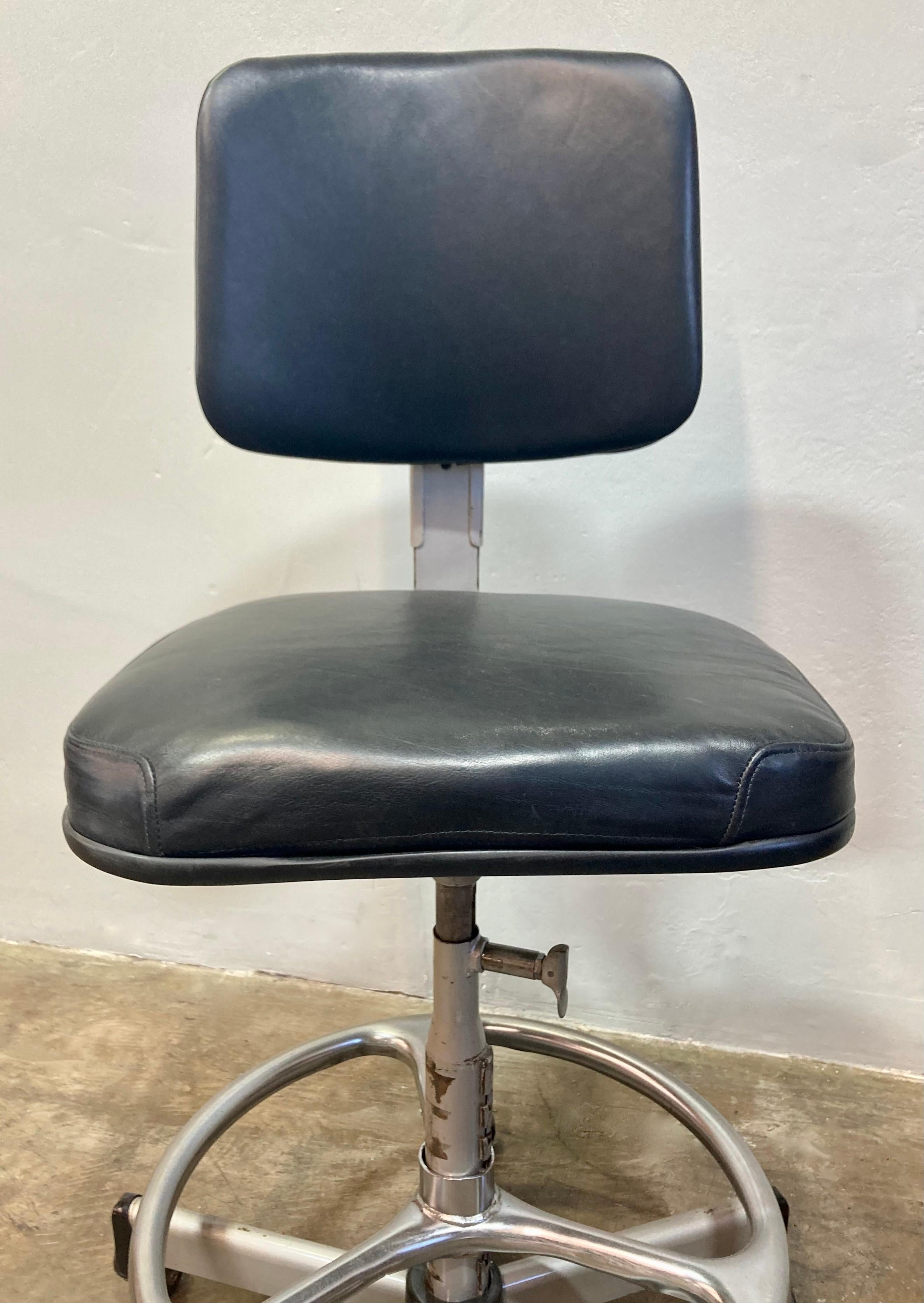 Taburete de redacción Cramer Industries de cuero y acero con ruedas. Nueva tapicería de cuero negro realizada recientemente en Los Ángeles, CA. Bastidor de acero en excelente estado vintage.  

22