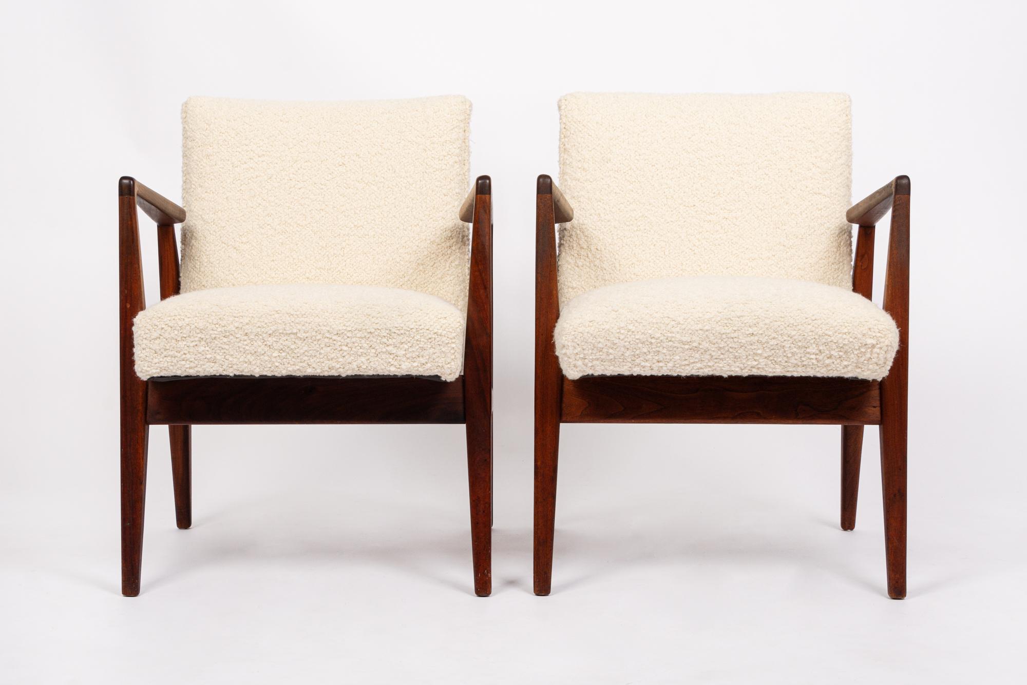 This pair of vintage mid century modern lounge chairs were designed by Jens Risom circa 1960. The classic Danish modern design has clean, minimalist lines and a striking sculptural profile. The lounge chairs feature well-built, solid walnut wood