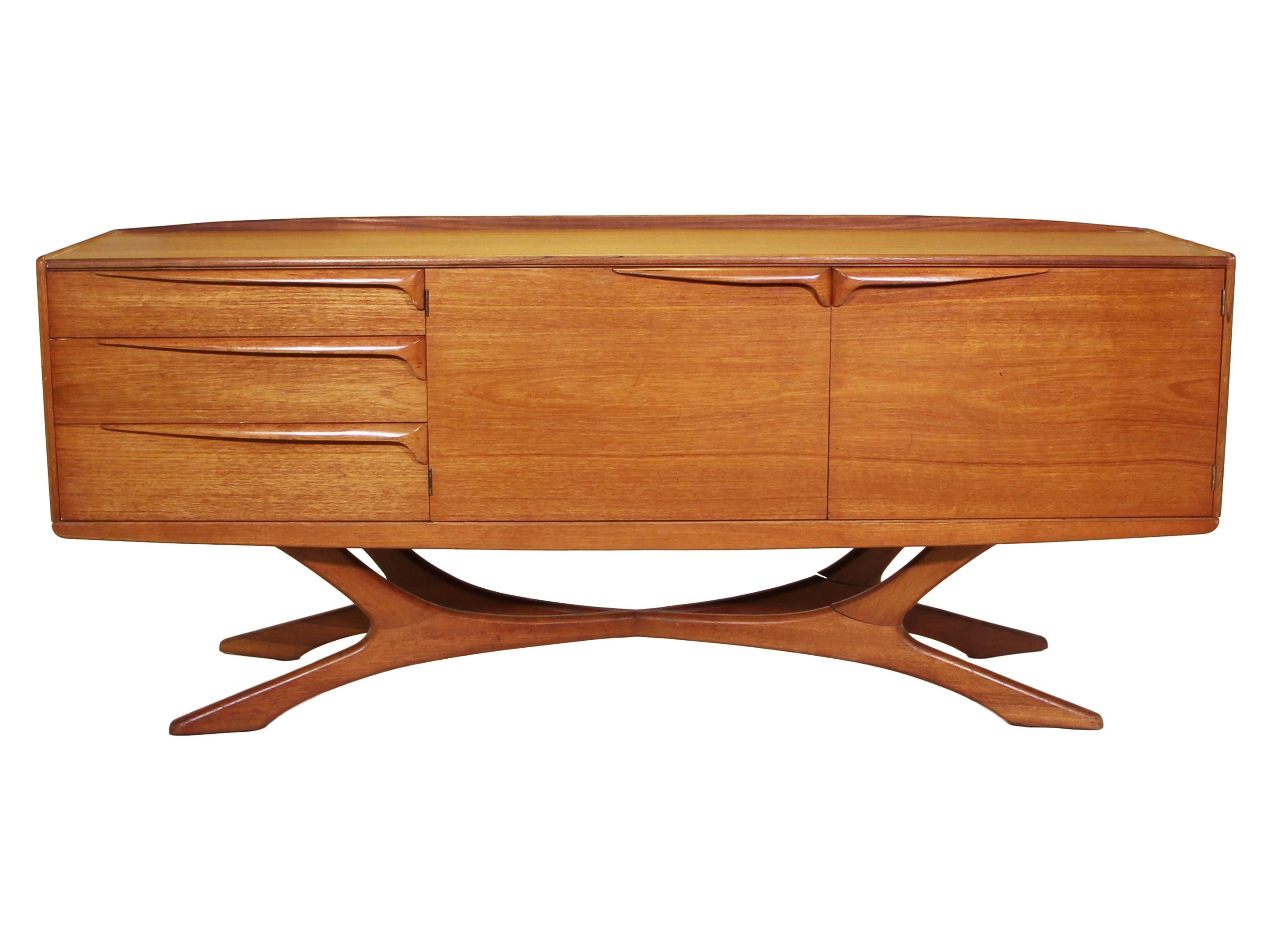 Midcentury credenza by Beithcraft. Only a limited number of these magnificent credenzas were made. The organic leg design and long sculpted handles make this piece the focal point of any room.

Very good vintage condition. The joints in the legs