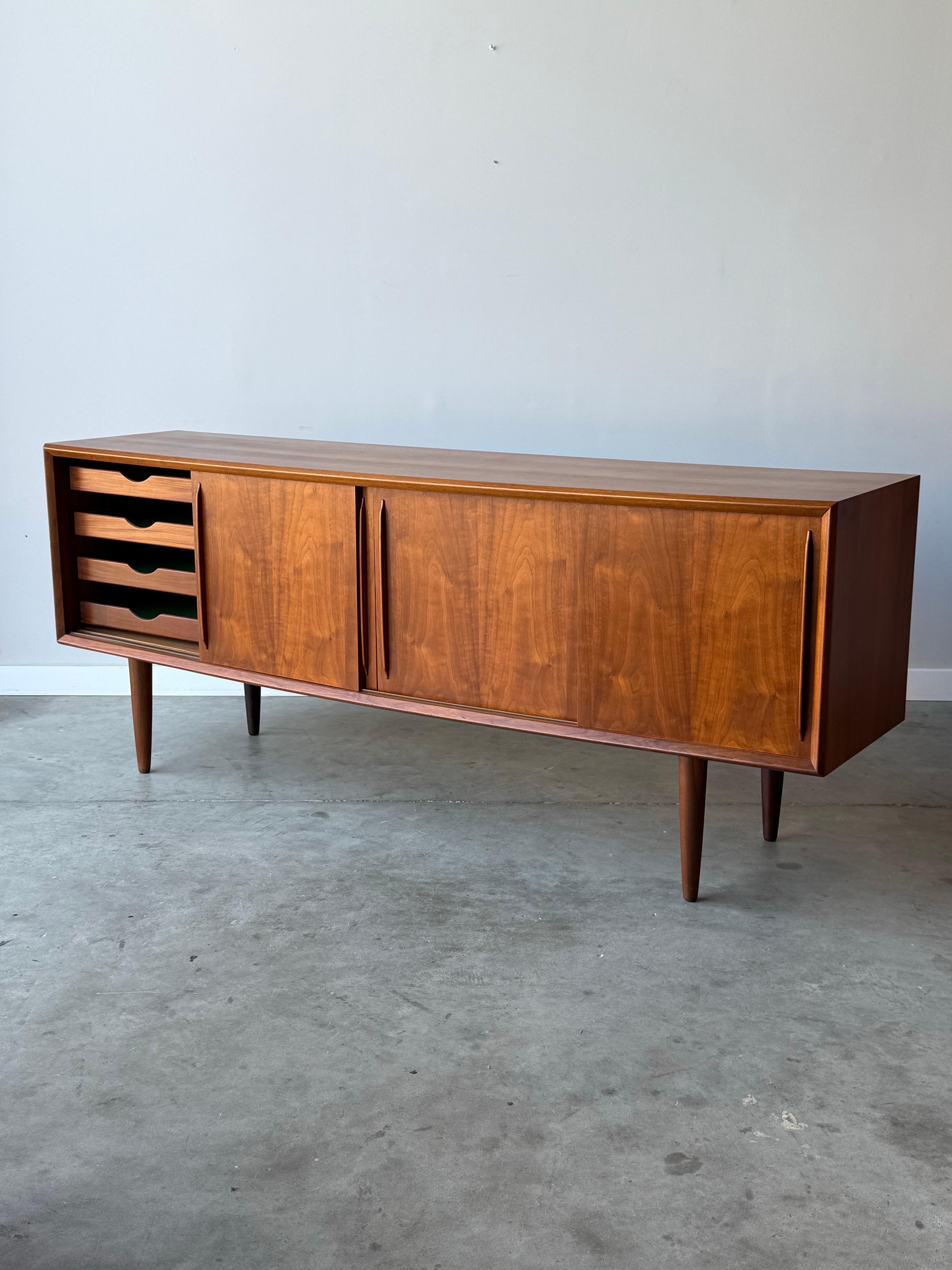 Absolutely stunning mid-century credenza designed by H.P. Hansen for Randers. This piece is a first for us, as it is seldom seen, yet has quickly become one of our favorites. 

The wood finish is warm in tone with incredible rich wood grain