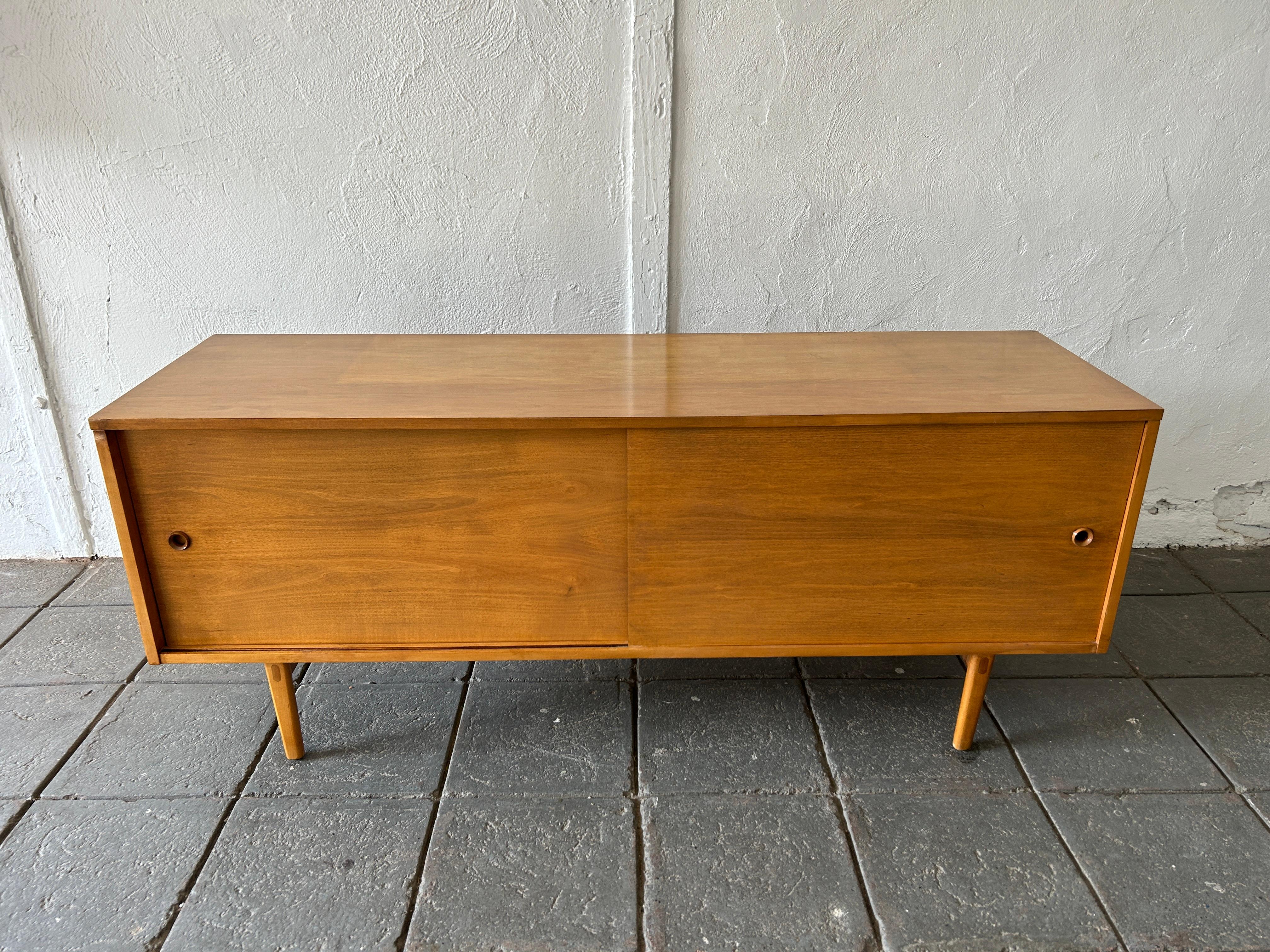 Beautiful mid-century low credenza cabinet with blonde maple sliding doors by Paul McCobb circa 1950 planner group #1513 has 2 adjustable shelves with pins - solid maple construction has a blonde maple finish. All original wood sliding front doors