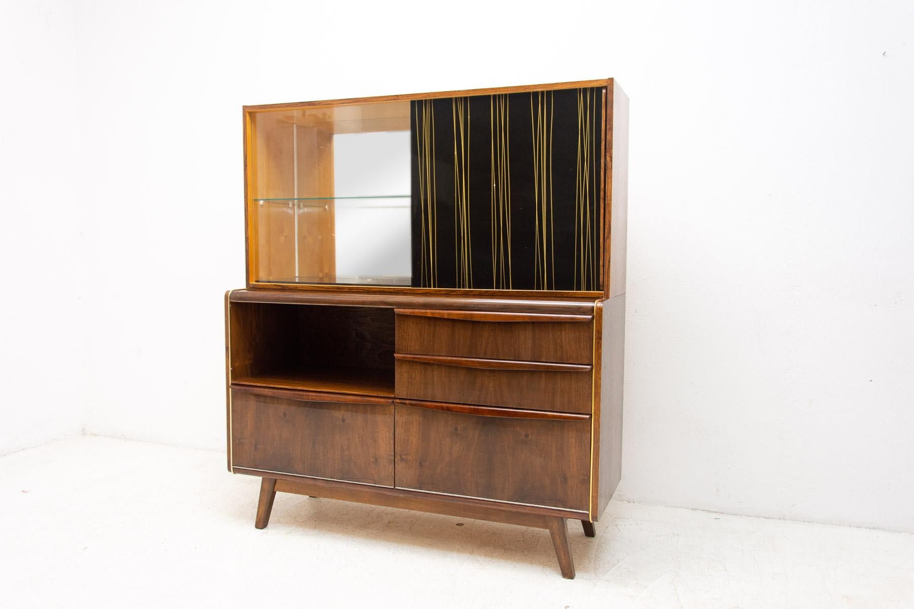 Mid-century credenza / cabinet with bar. It was designed by Hubert Nepožitek & Bohumil Landsman for Jitona company under serial No. U-300 in the 1960´s. It features a glazed upper section with glass shelf to the left and laminated doors to the