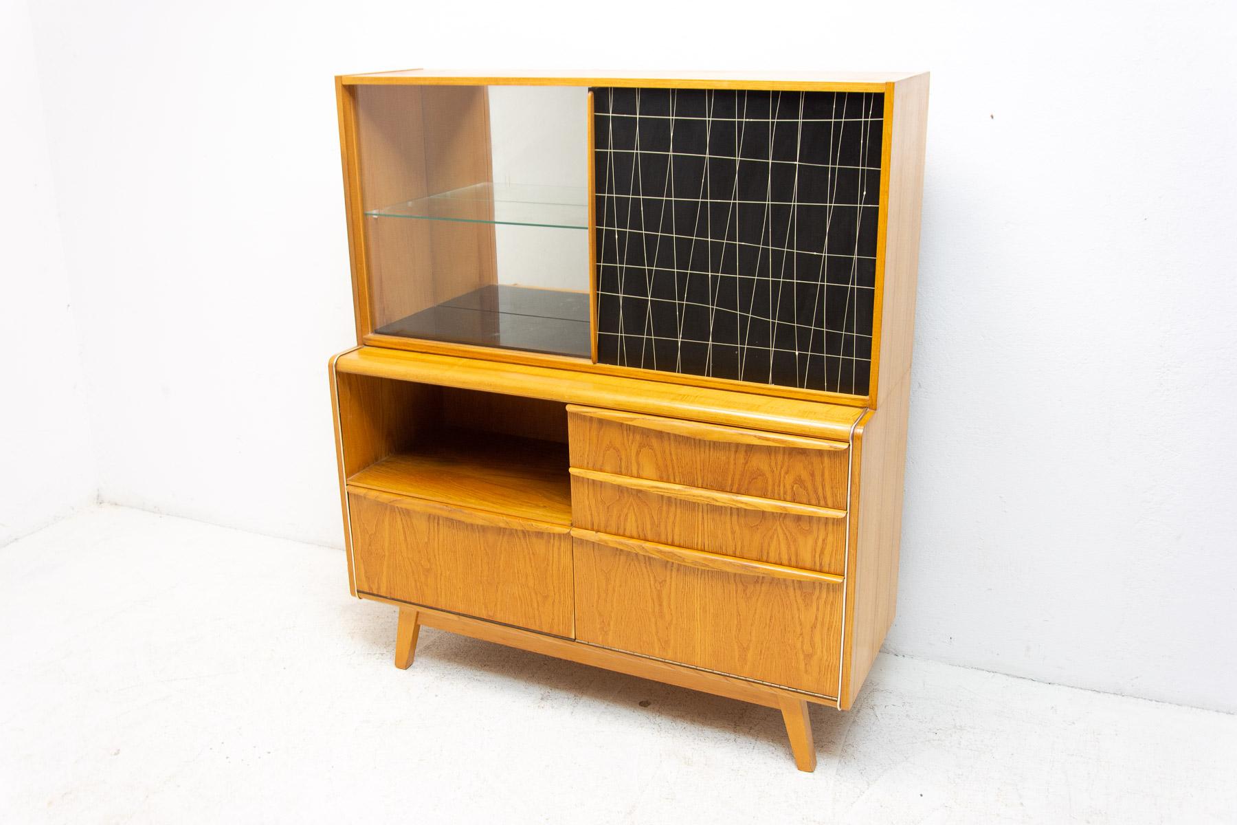 Mid-century credenza/cabinet with bar. It was designed by Hubert Nepožitek & Bohumil Landsman for Jitona company under serial No. U-300 in the 1960´s. It features a glazed upper section with glass shelf to the left and laminated doors to the right,