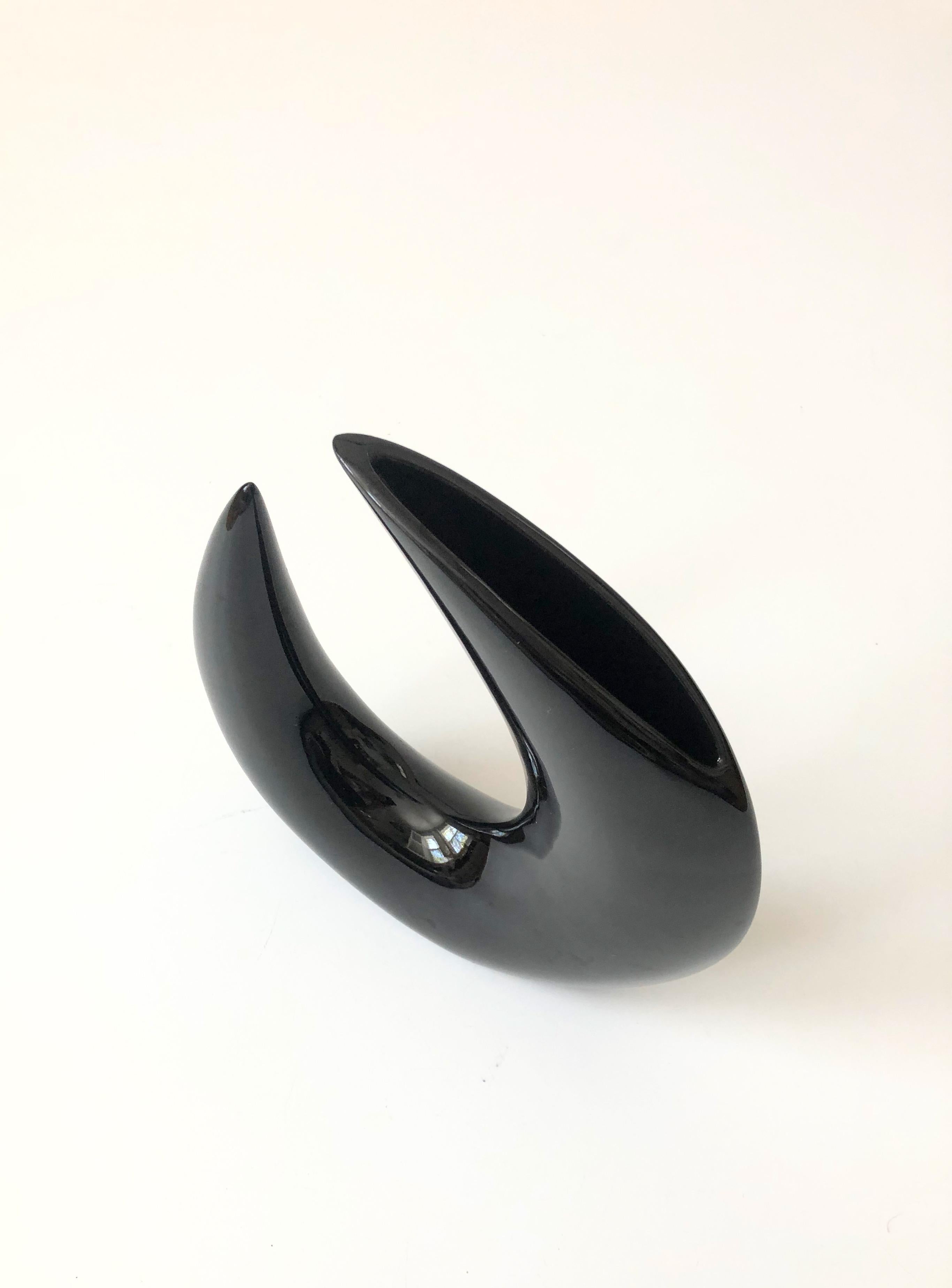 A mid-century crescent moon shaped ceramic. Finished in a glossy black glaze. A great sculptural accent piece. Made in Japan.
 
