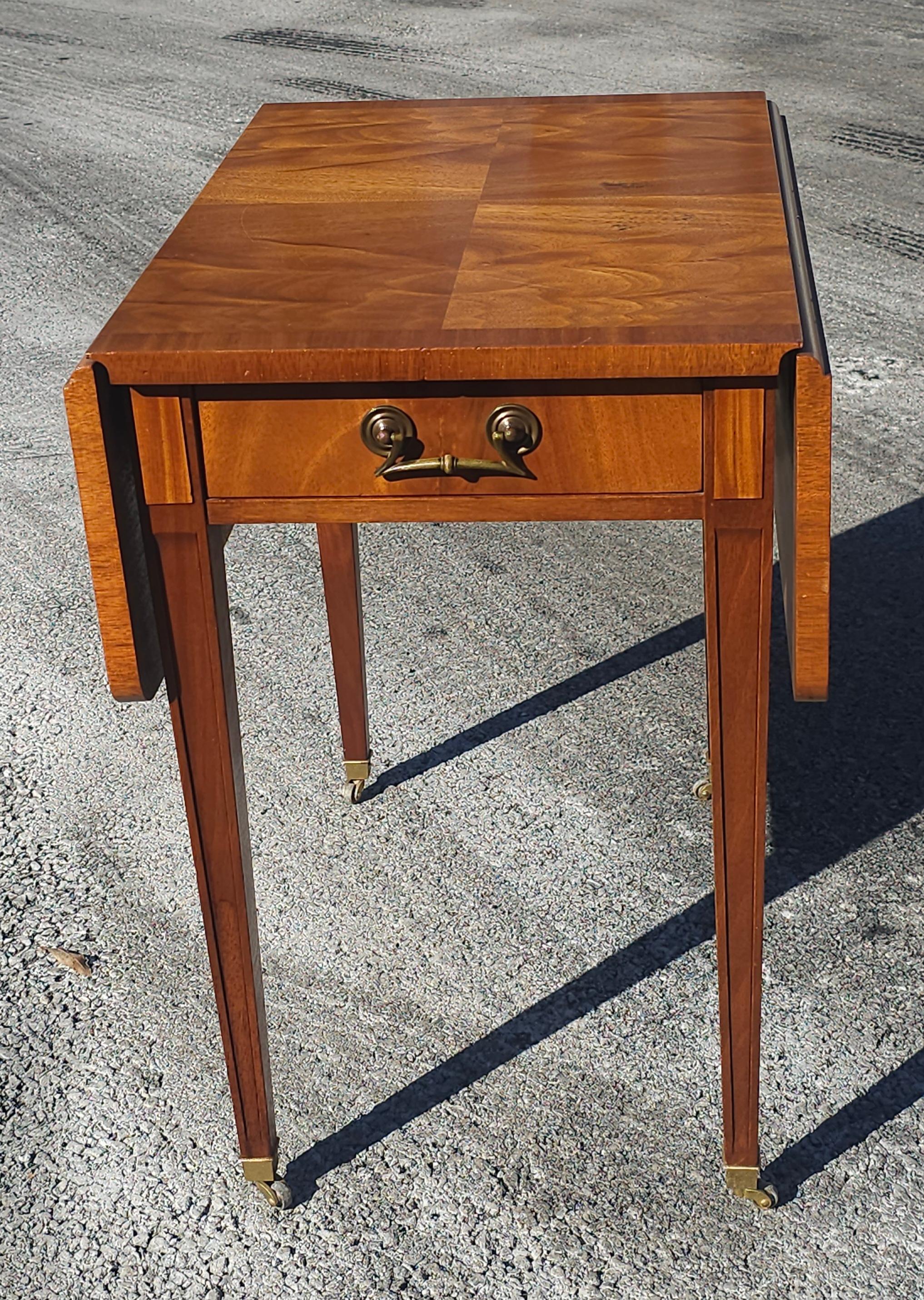 A Mid 20th Century Cross-Banded Crotched Mahogany Pembroke / Drop-Leaf Rolling Table. Brass cup rolling wheels.
Measures 18