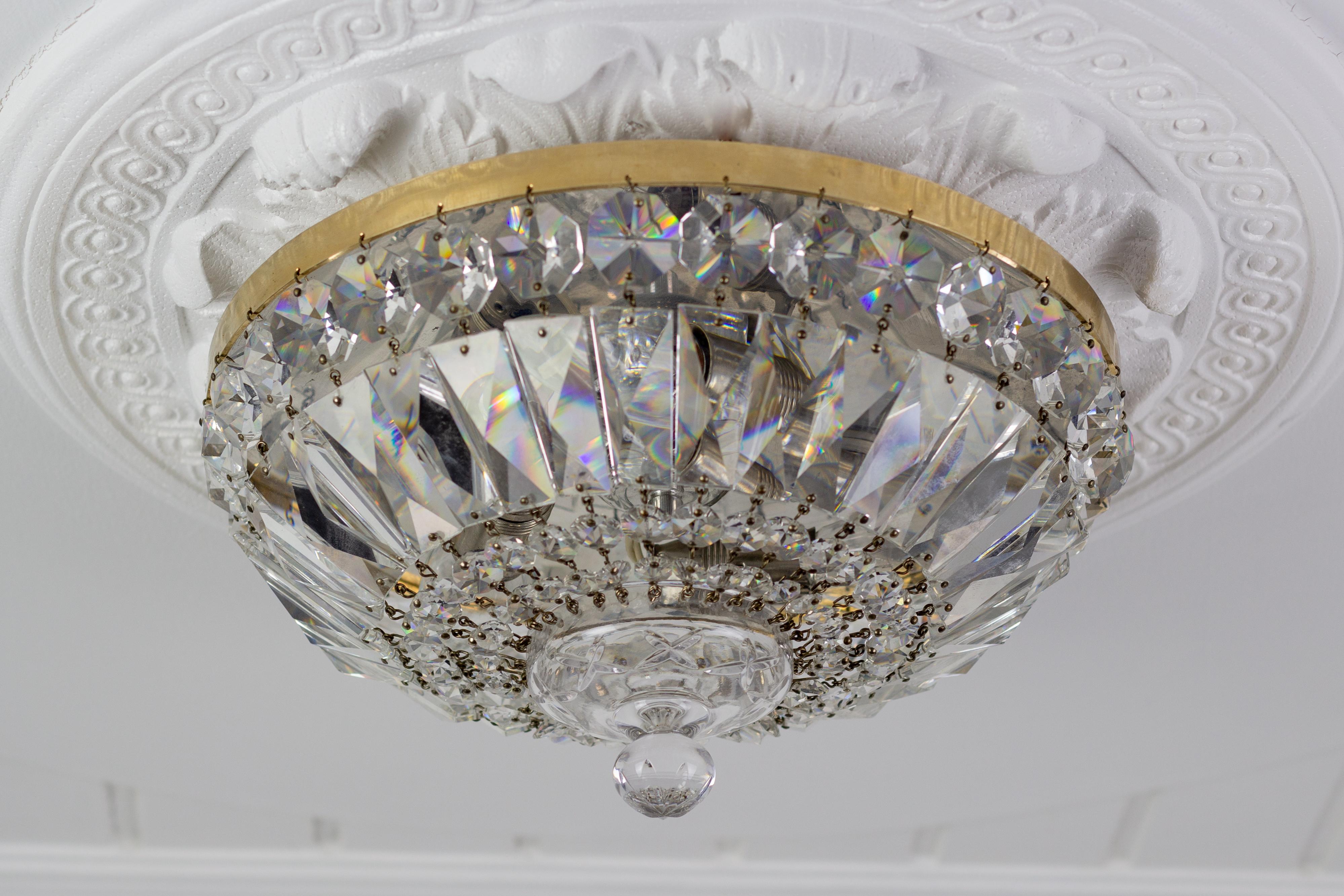 This wonderful ceiling fixture features clear crystal prisms mounted on a brass outer ring and centered with a glass finial.
Three interior lights - three sockets for E14-size light bulbs.
Dimensions: height: 14.5 cm / 5.7 in; diameter: 29 cm /