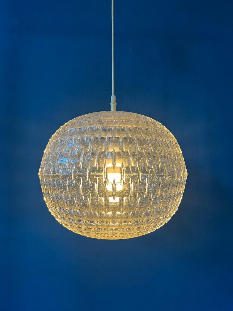 Big mid century crystal glass pendant lamp. This lamp is made out of very thick plexiglass. The christal structure of the glass spreads the light nicely. The lamp requires one E27/26 lighbulb.

Additional information:
Materials: Metal, plastic,
