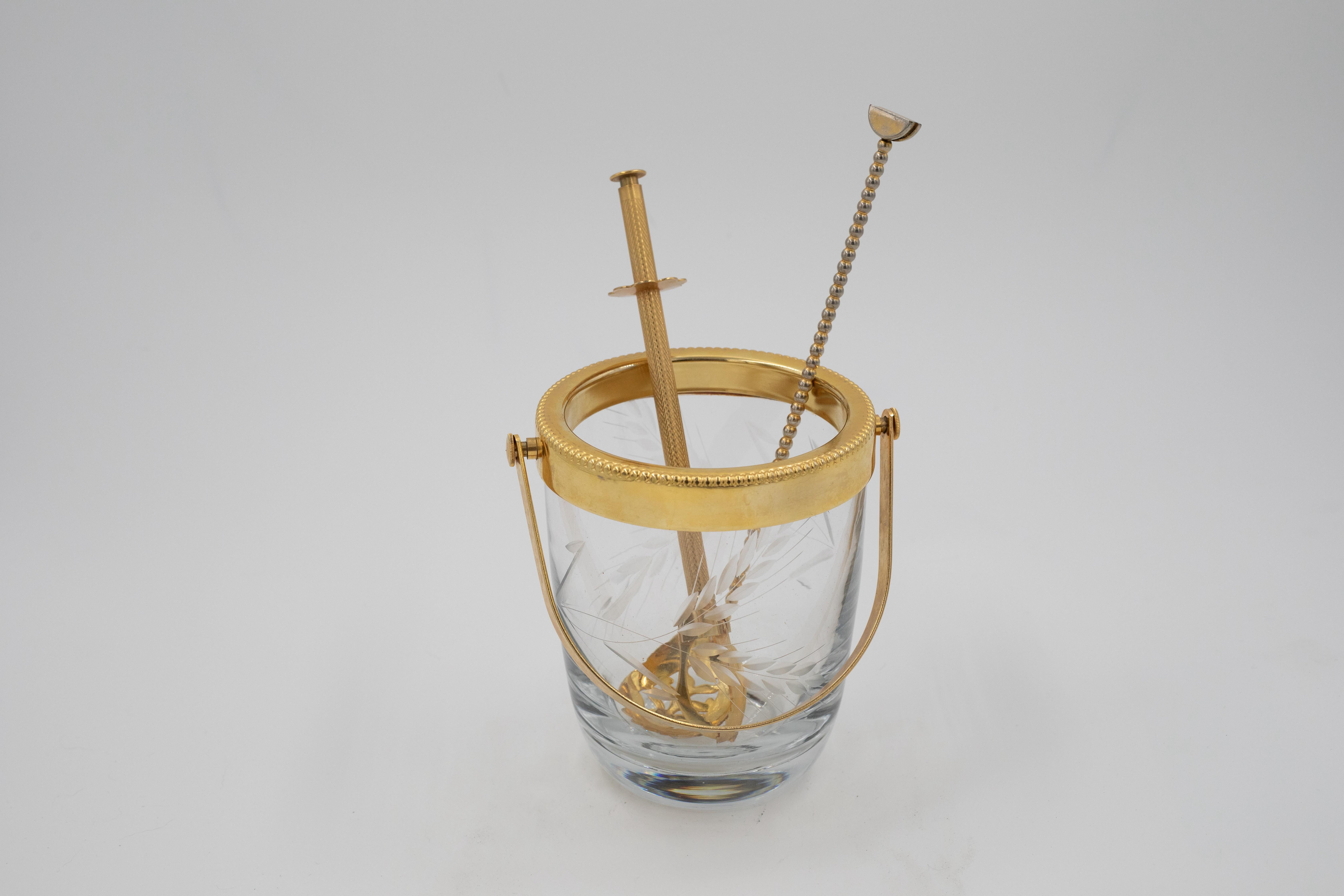 Seau à glace en cristal raffiné du milieu du siècle, présentant un motif de blé magnifiquement gravé, associé à un élégant collier en laiton doré et à une poignée pivotante. Les parois de cristal sont d'une clarté et d'un poids exceptionnels, tandis