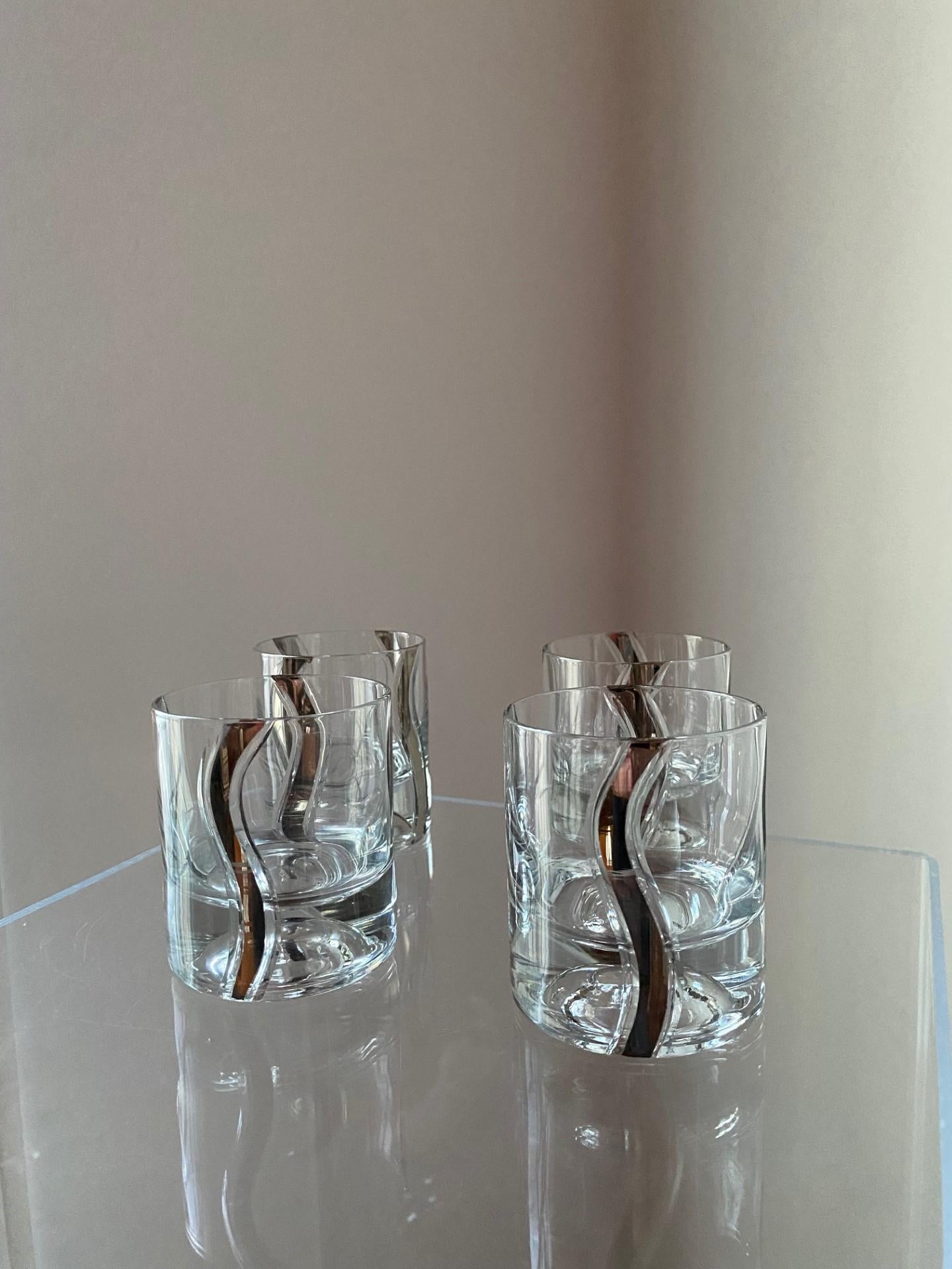 Beautiful set of 4 old fashioned glasses.  These vintage, mid-century beauties dazzled with sparkle and platinum shimmer.  Each vintage glass piece has a solid base, with platinum ribbon designs that ondulate from top to bottom creating a chic and